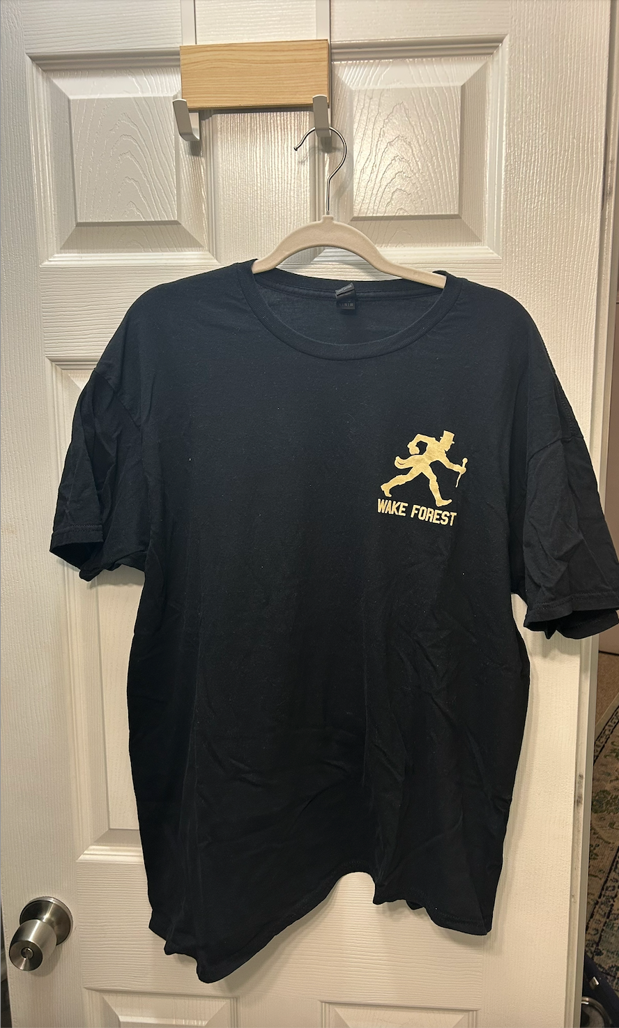 Black Wake Forest University short-sleeve t-shirt featuring the Demon Deacon mascot logo in gold.