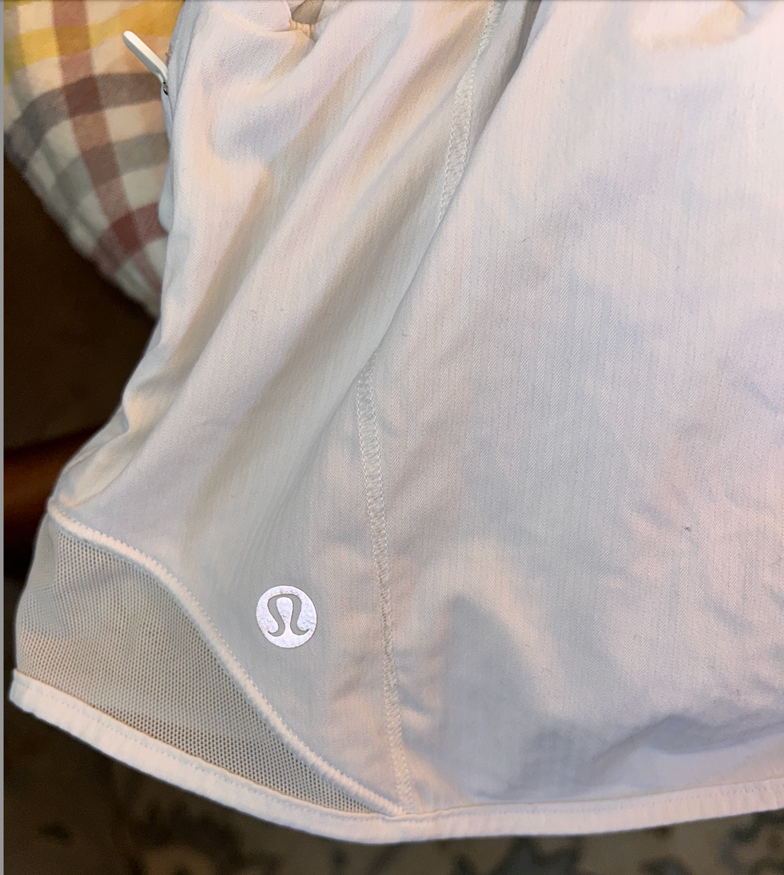 Lululemon white lightweight athletic running shorts with built-in liner and side cutout details.