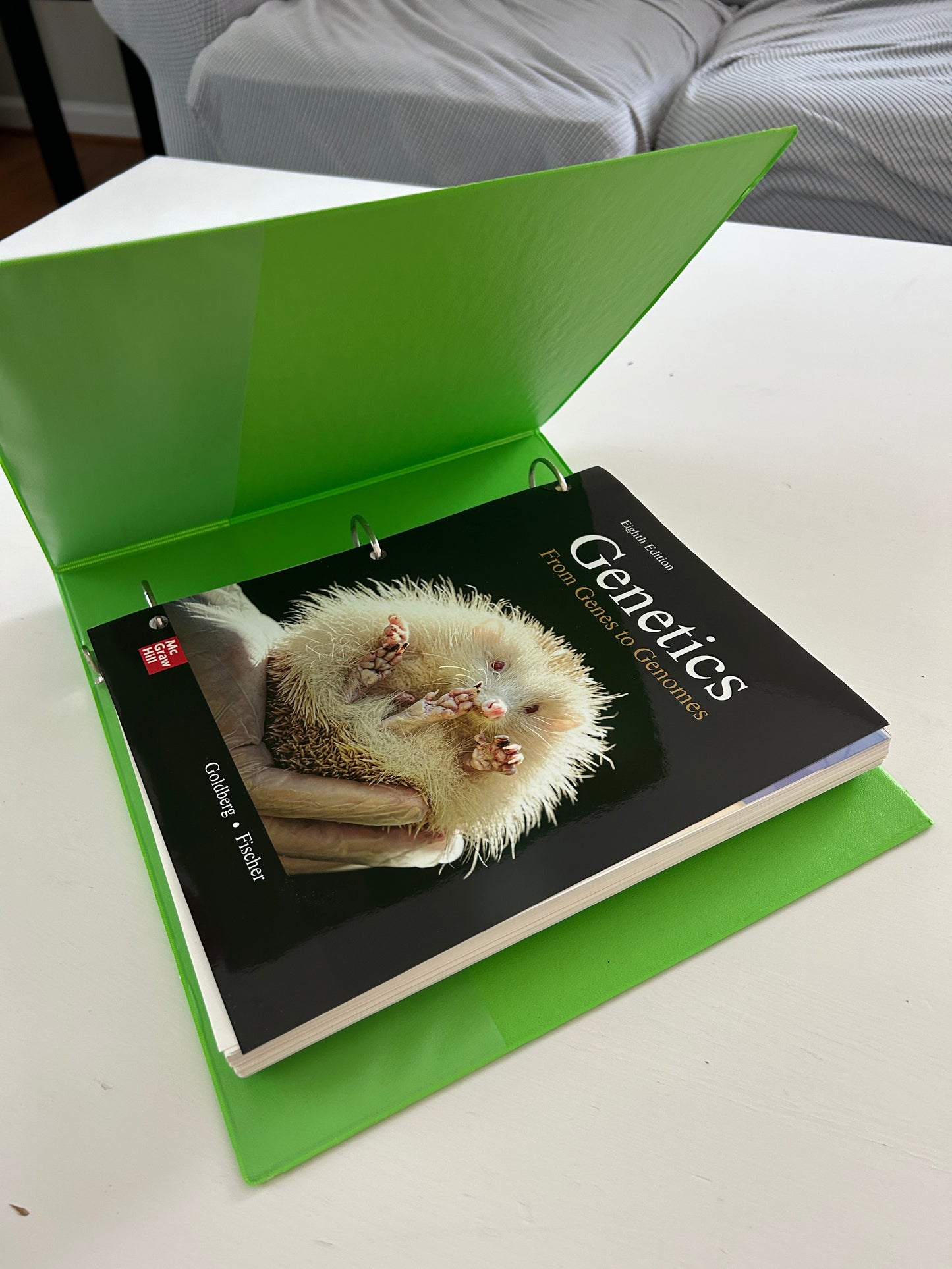 Genetics: From Genes to Genomes textbook, Eighth Edition by Goldberg and Fischer, published by McGraw Hill, in a three-ring binder.
