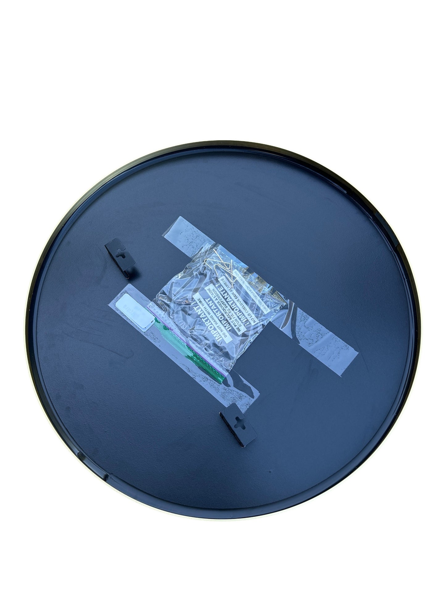 Round wall mirror with a thin gold frame.