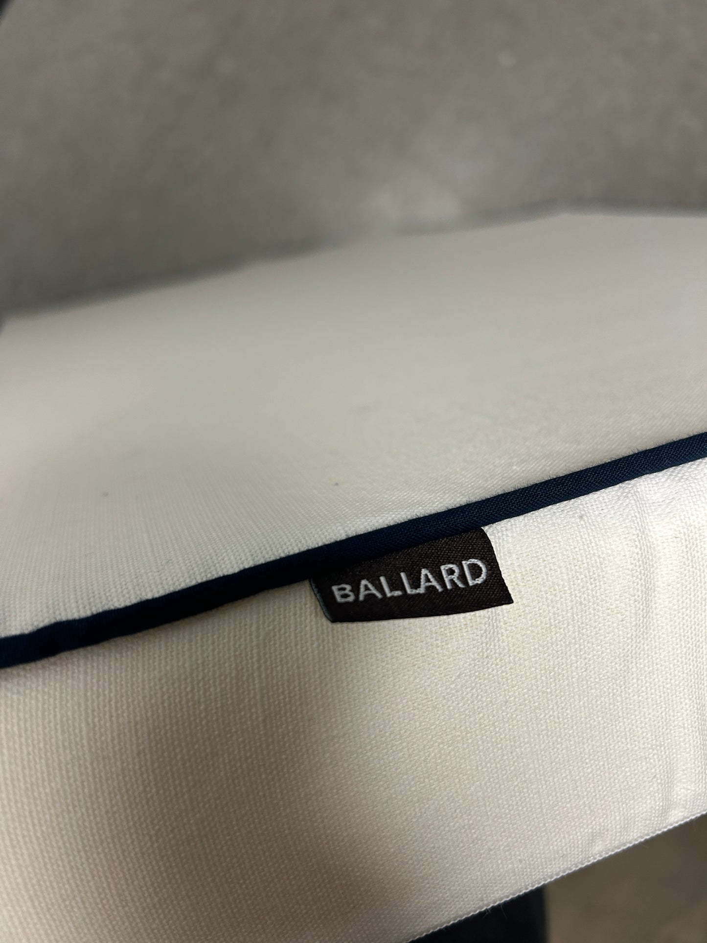 Ballard twin white headboard with navy blue piping trim along the edges.