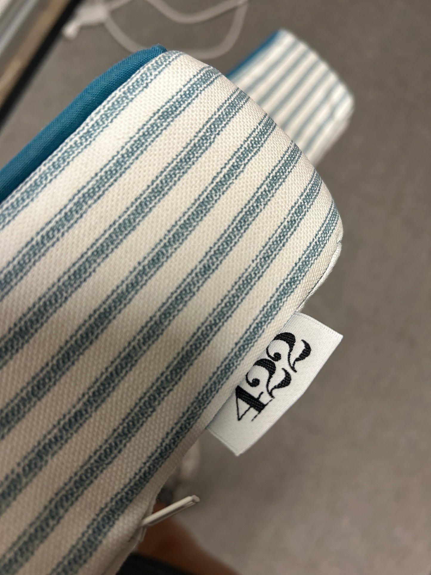 Room 422 twin blue and white striped headboard with blue piping trim along the edges.