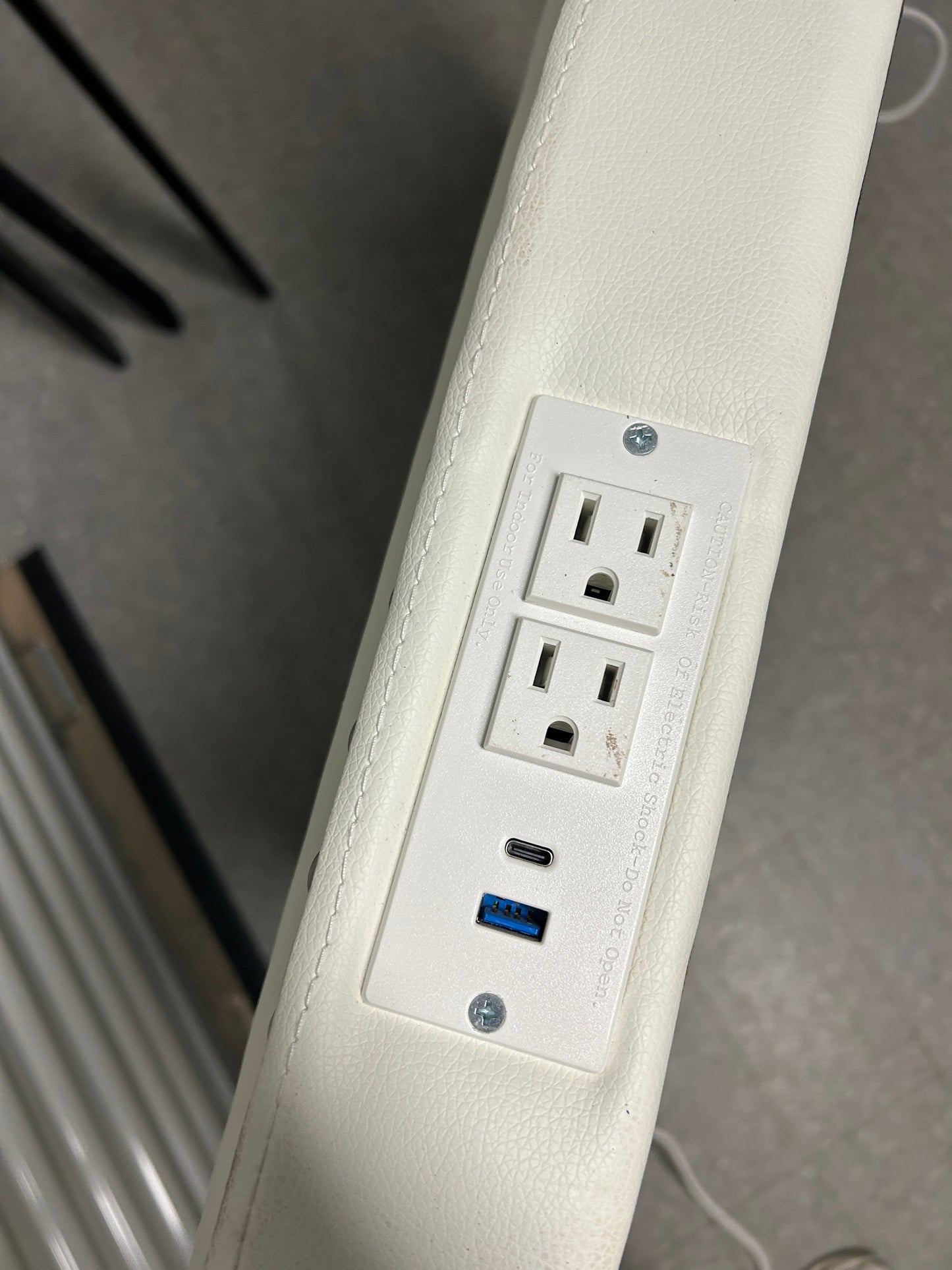White twin headboard with silver buttons and a charging outlet.