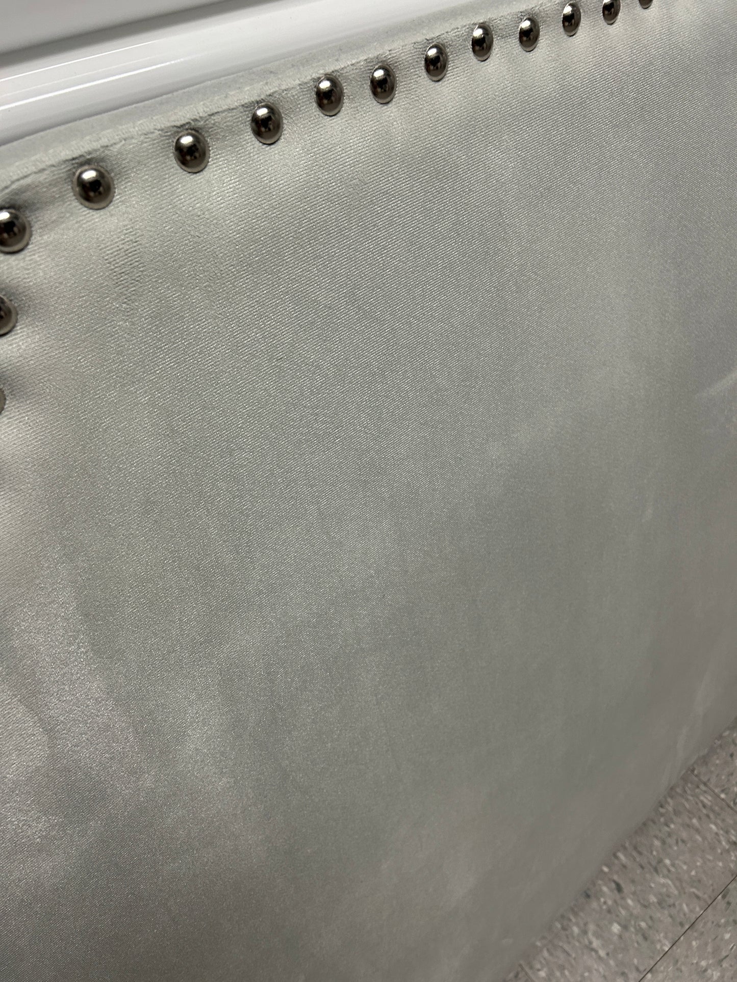 Gray velvet twin headboard with silver buttons.