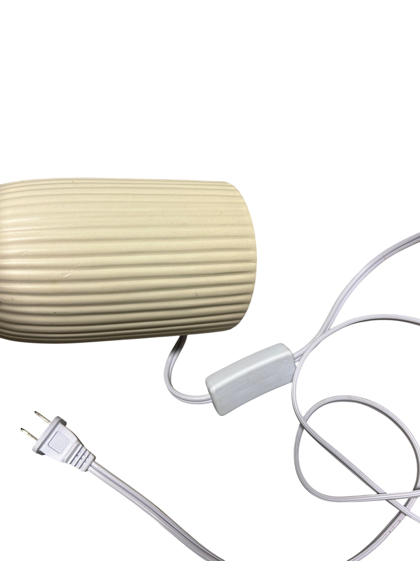 A cream table lamp with a ribbed ceramic base.