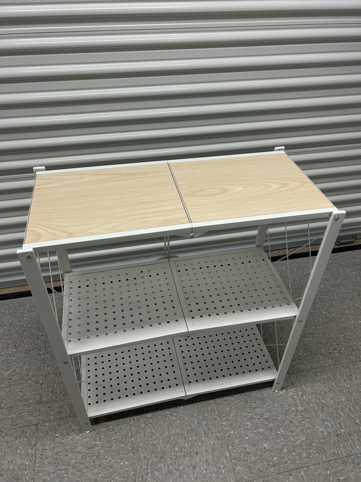 3-tier white metal storage shelf with light wood top.
