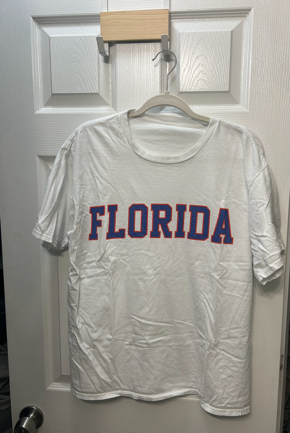 White short-sleeve t-shirt with "FLORIDA" printed in blue and orange collegiate lettering.