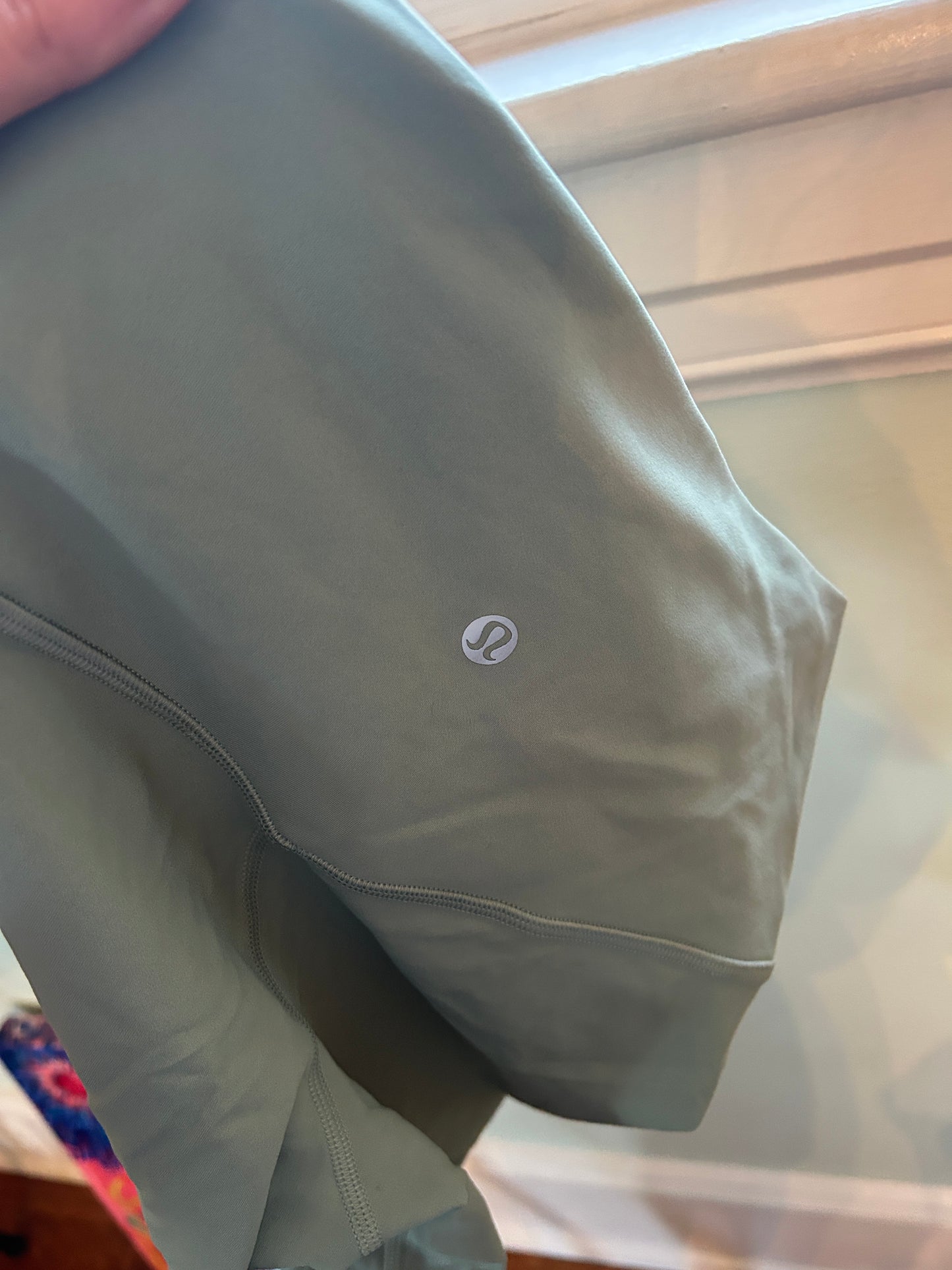 Lululemon olive green high-waisted biker shorts with a wide waistband, suitable for athletic or casual wear.