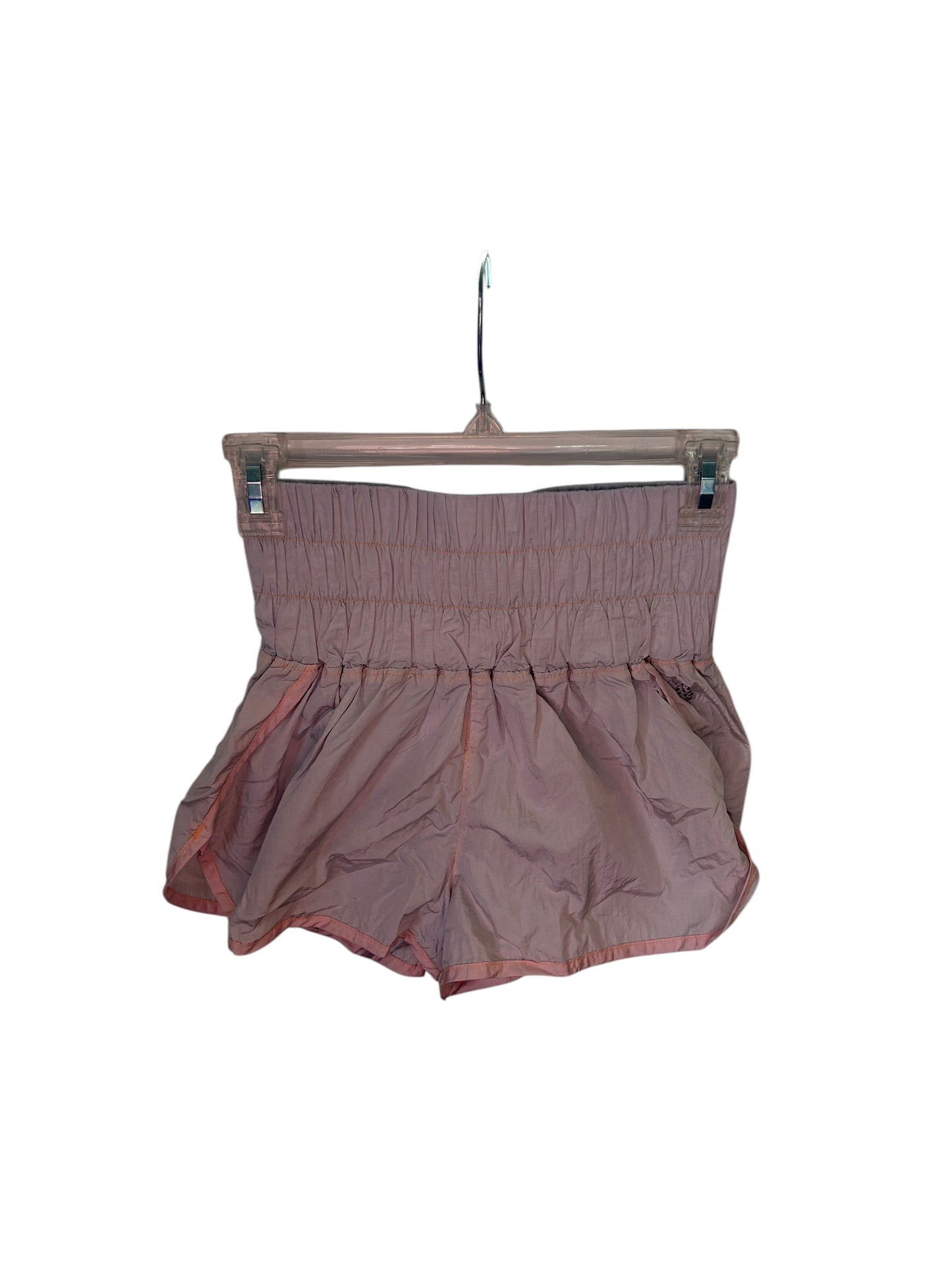 Free People lightweight athletic shorts with high elastic waistband and flowy silhouette in dusty pink.