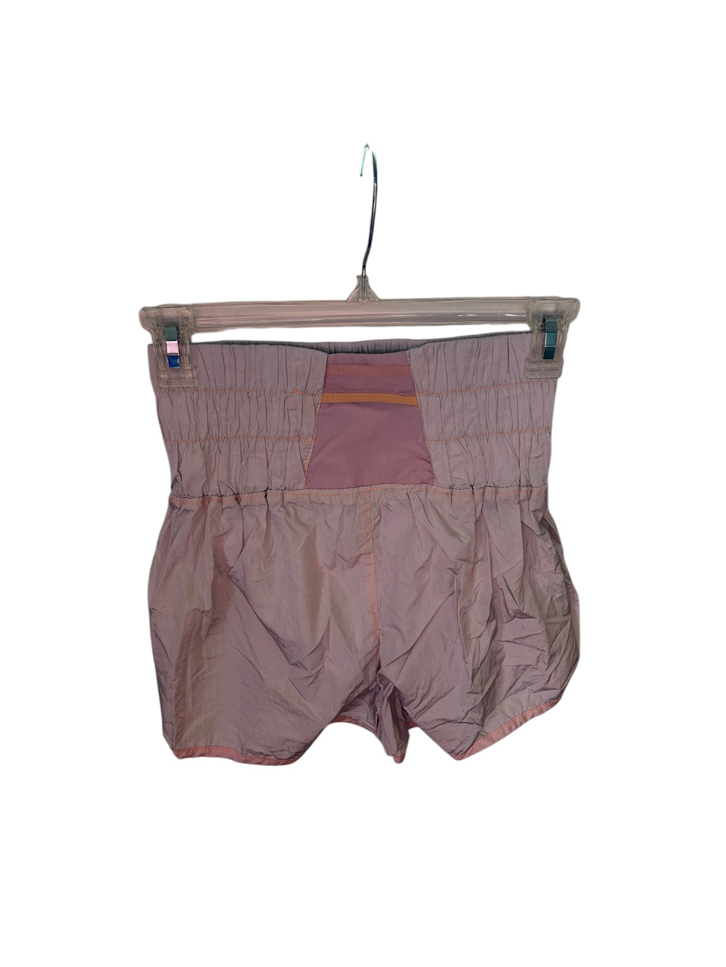 Free People lightweight athletic shorts with high elastic waistband and flowy silhouette in dusty pink.