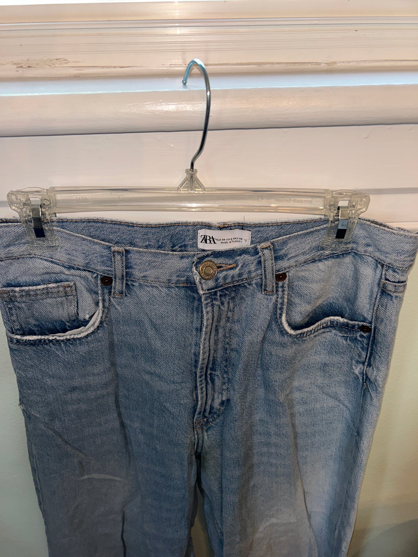 Zara light wash denim jeans with raw hem detailing and a relaxed straight leg fit.
