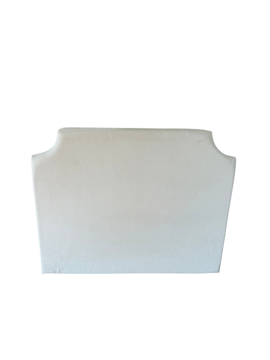Cream upholstered headboard with curved camelback silhouette.