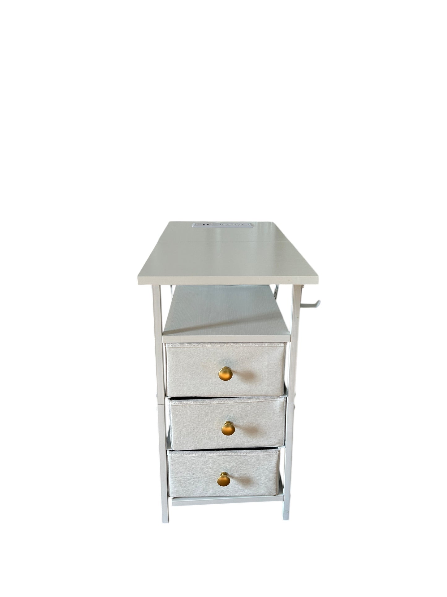Compact white nightstand with three fabric drawers and gold knobs, featuring an open shelf and metal frame.