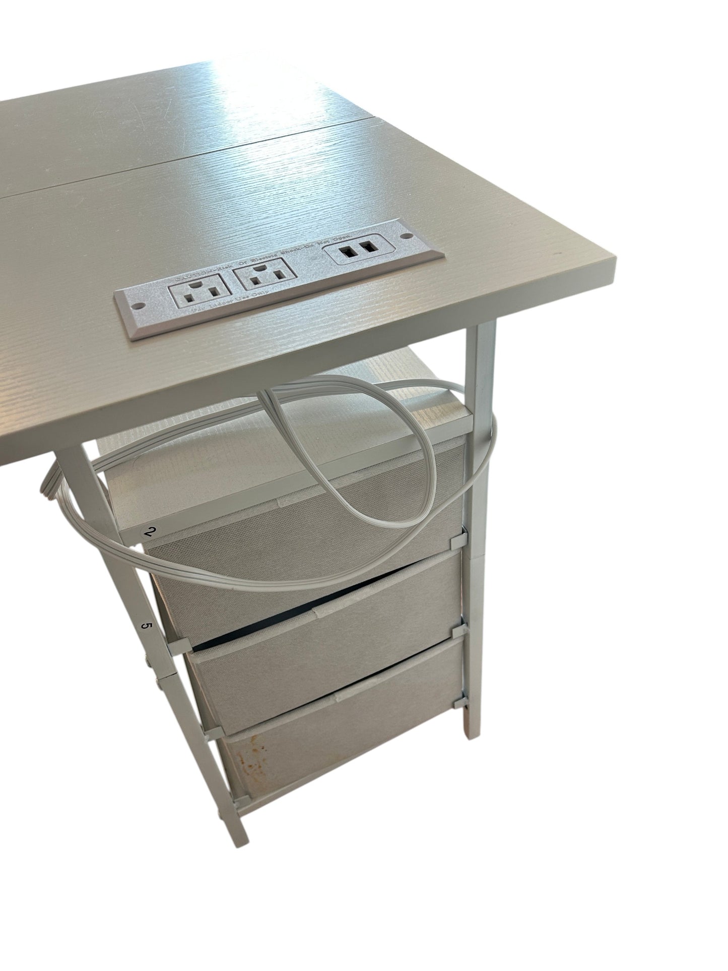 Compact white nightstand with three fabric drawers and gold knobs, featuring an open shelf and metal frame.