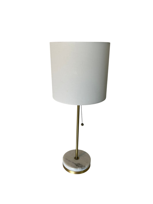 Modern table lamp with white drum shade, brass stem, and marble base with pull chain switch.