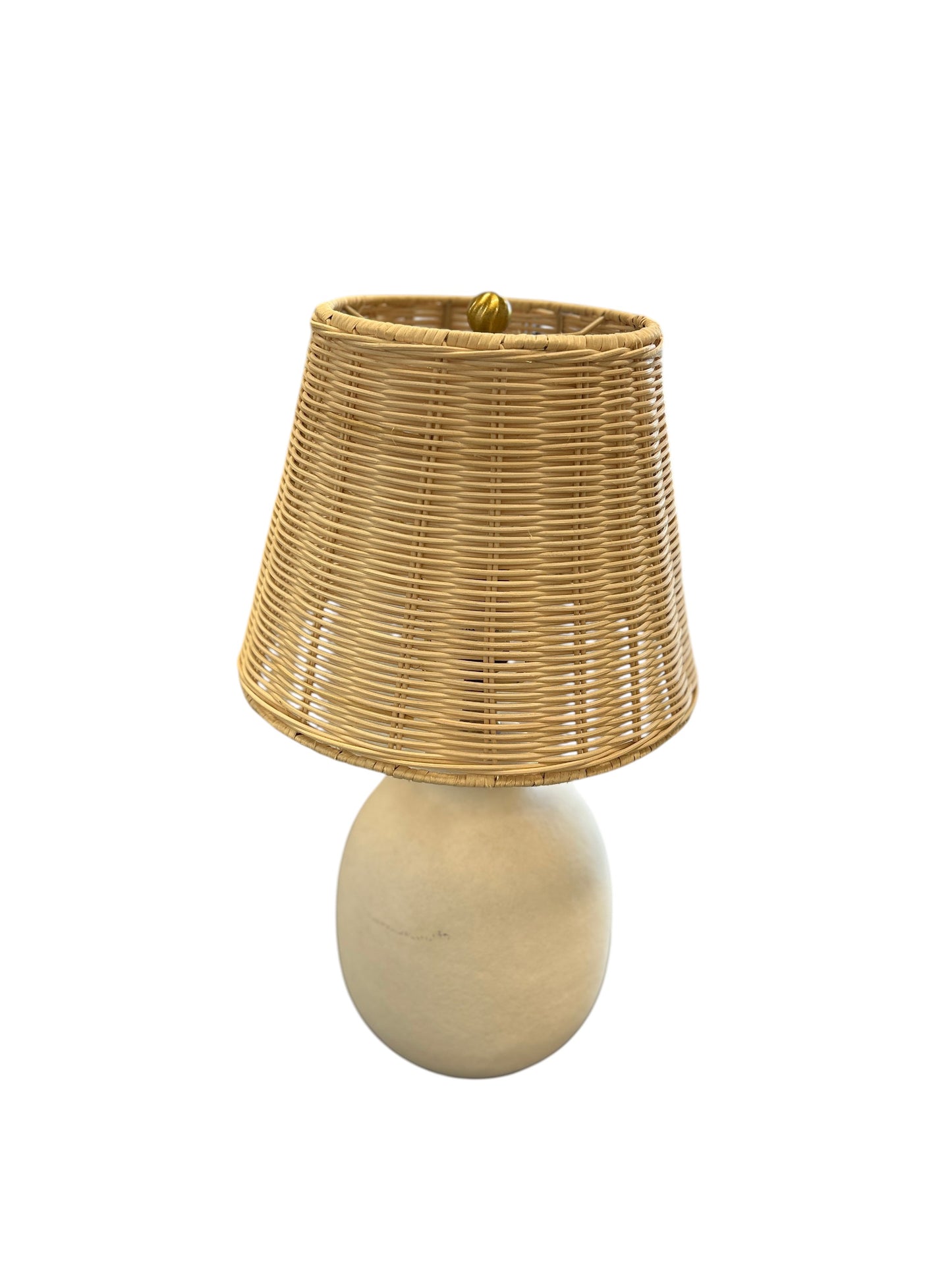 Table lamp with a rounded cream ceramic base and natural woven shade.