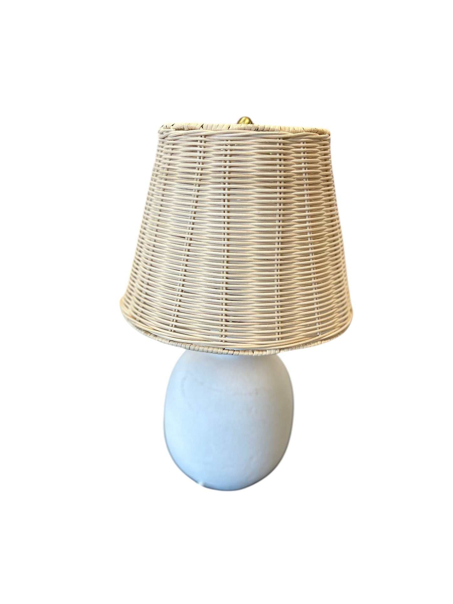 Table lamp with a rounded cream ceramic base and natural woven shade.