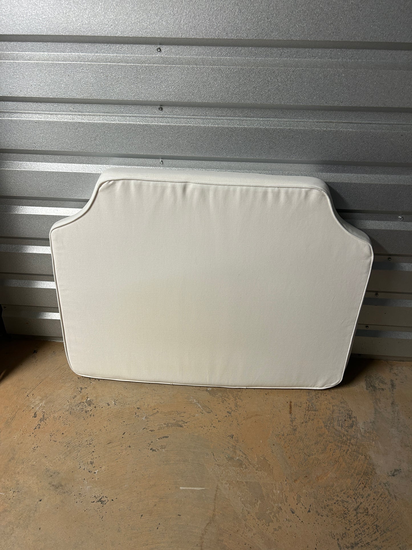 Room 422 twin white headboard with white piping trim along the edges.