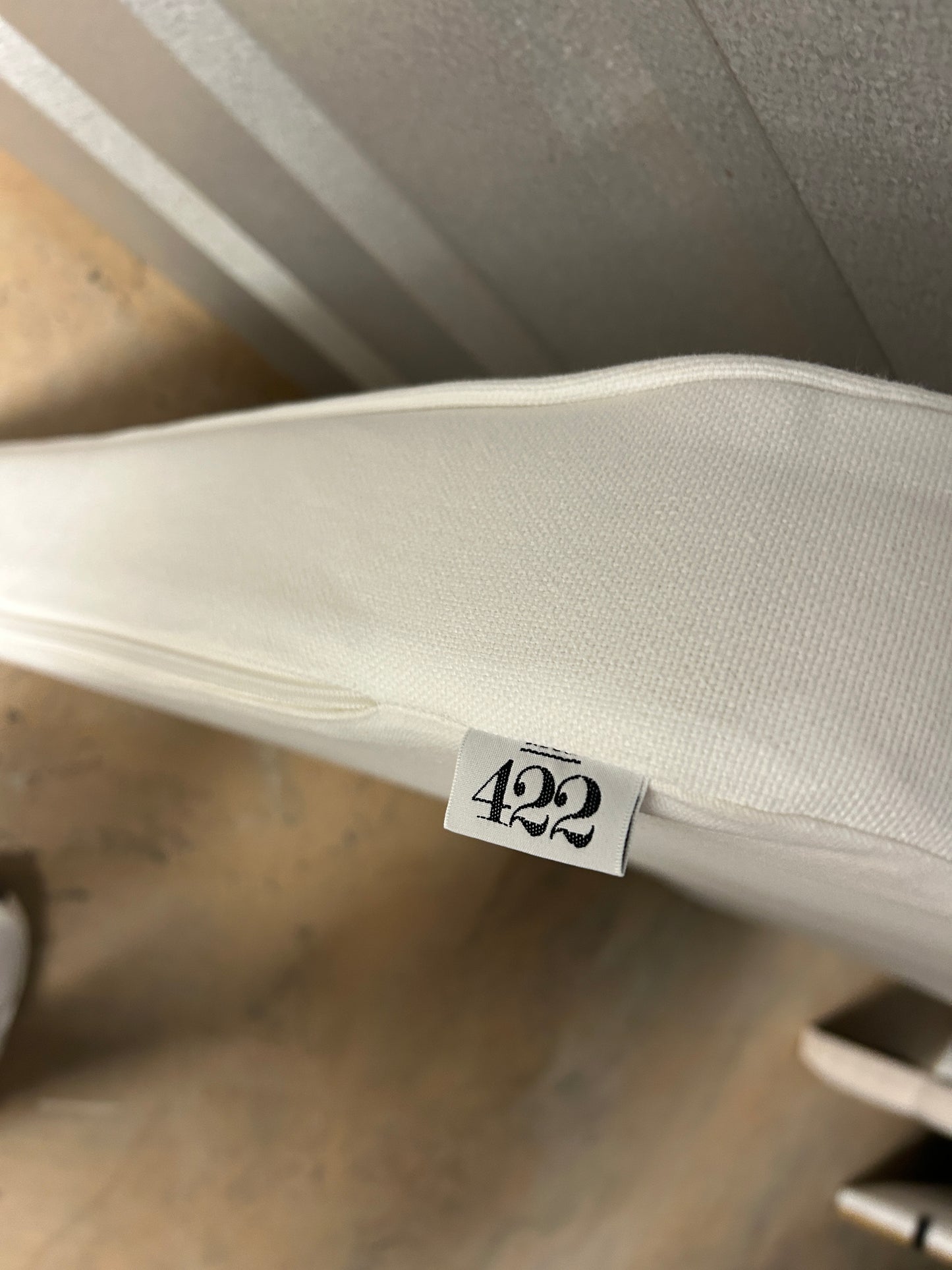 Room 422 twin white headboard with white piping trim along the edges.