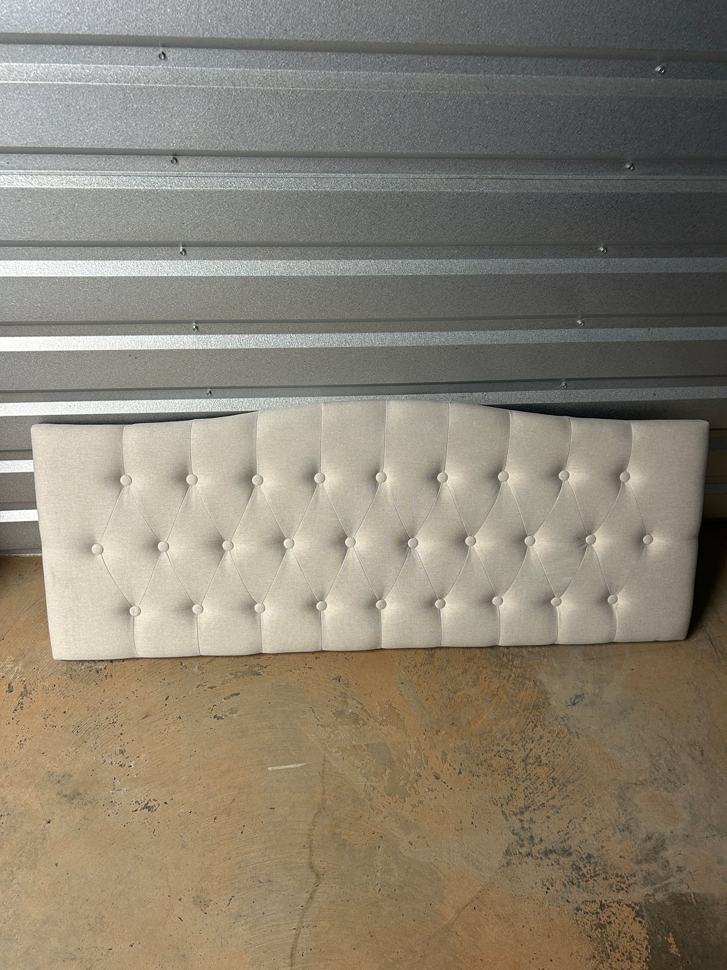 Cream full/queen upholstered tufted headboard with diamond button pattern.
