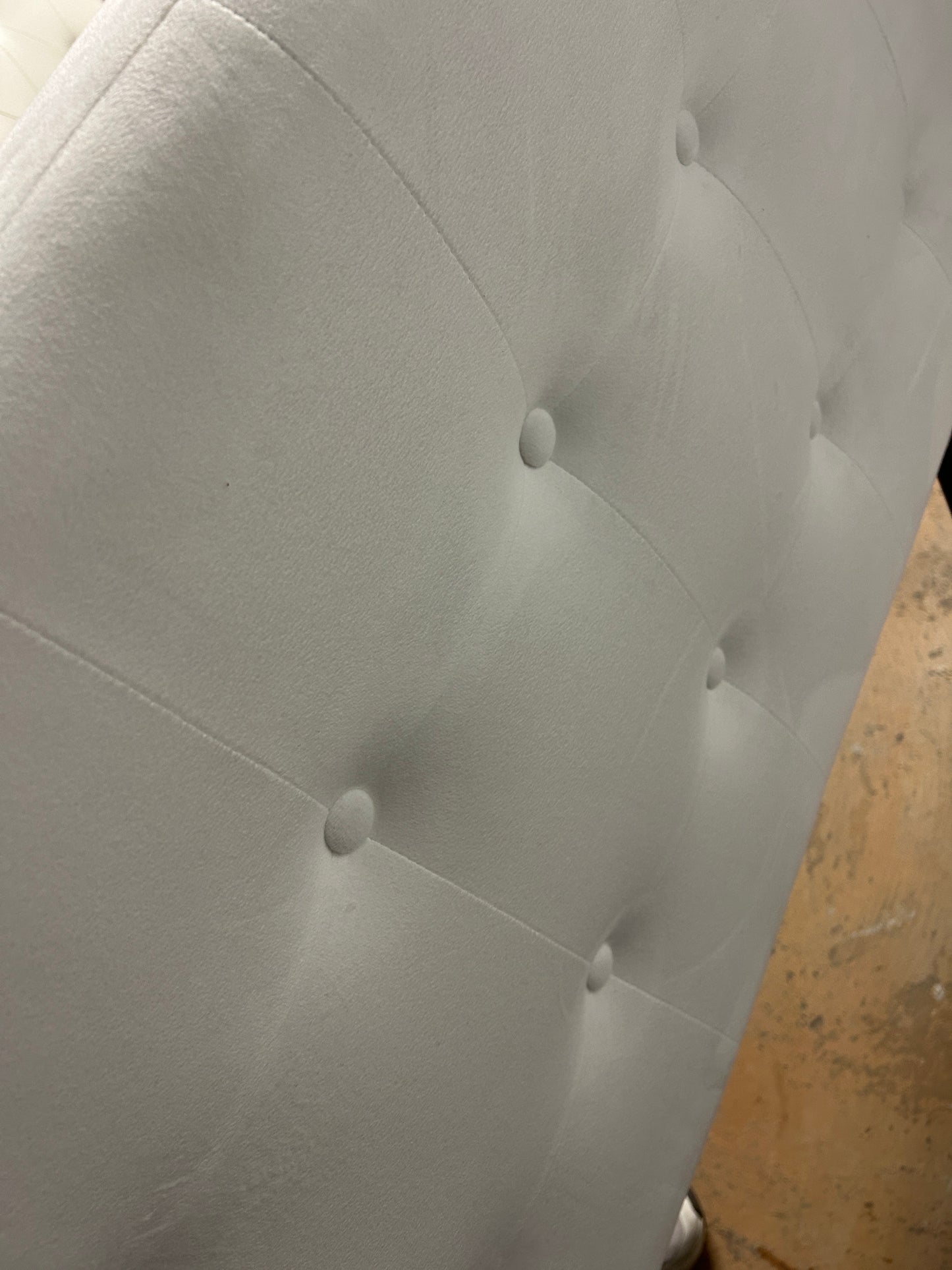 White twin velvet headboard with black metal legs.