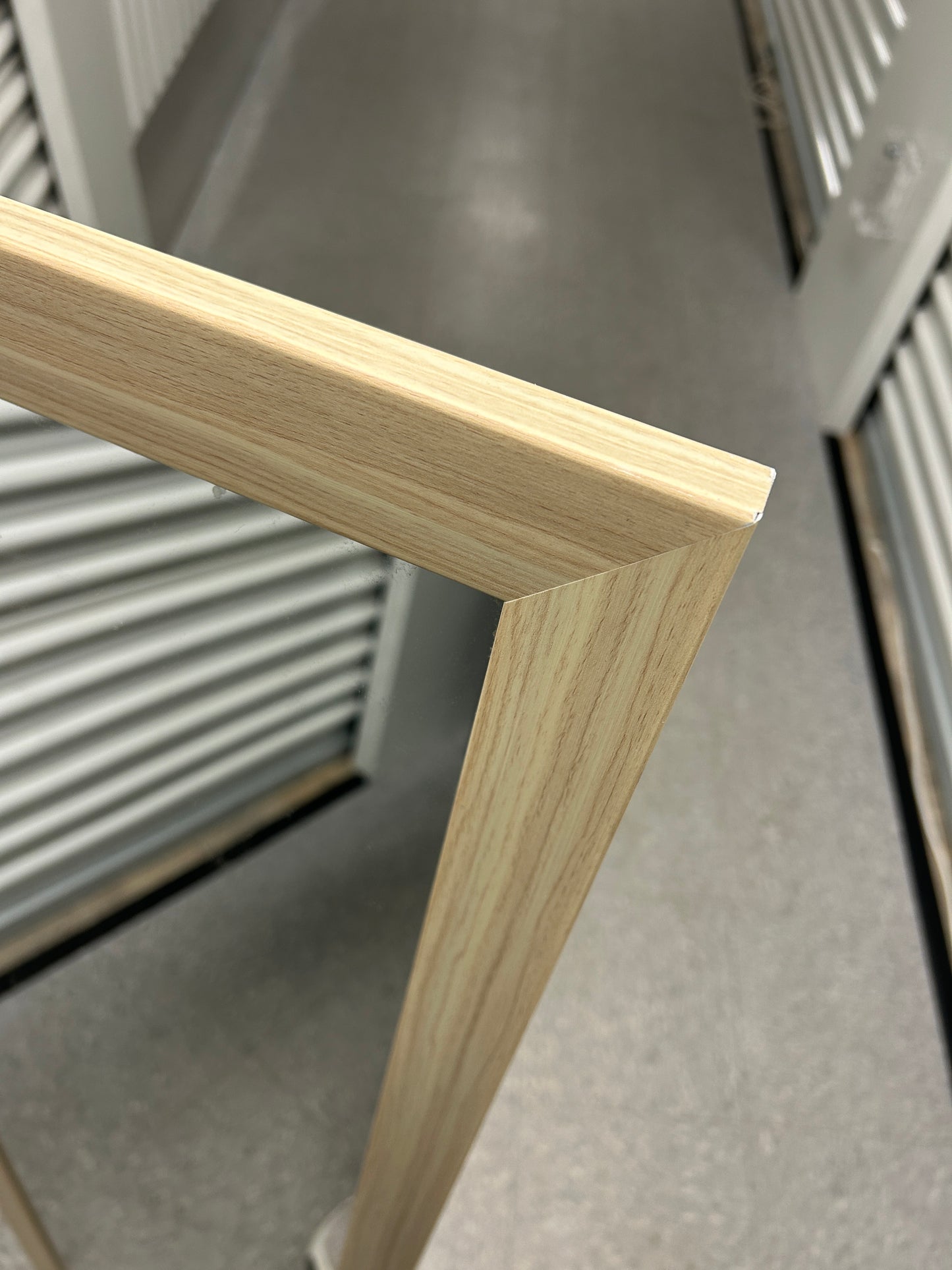 Full-length standing mirror with a light wood frame.
