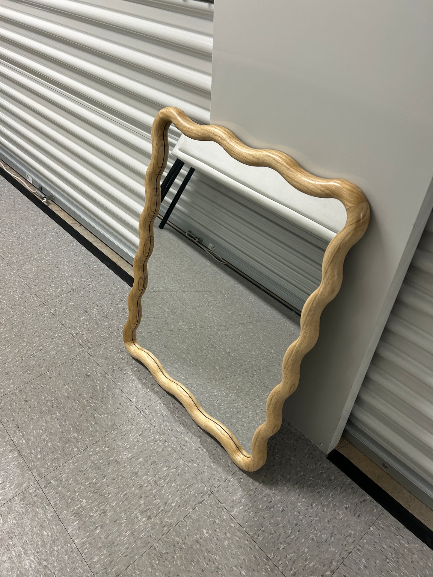 Target scalloped wall mirror with natural wood frame.