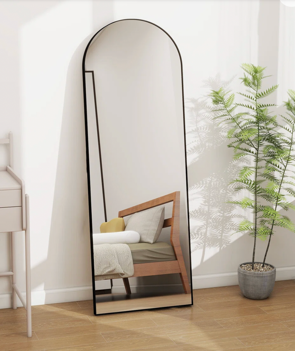 Wayfair arched full-length standing floor mirror with a black frame.