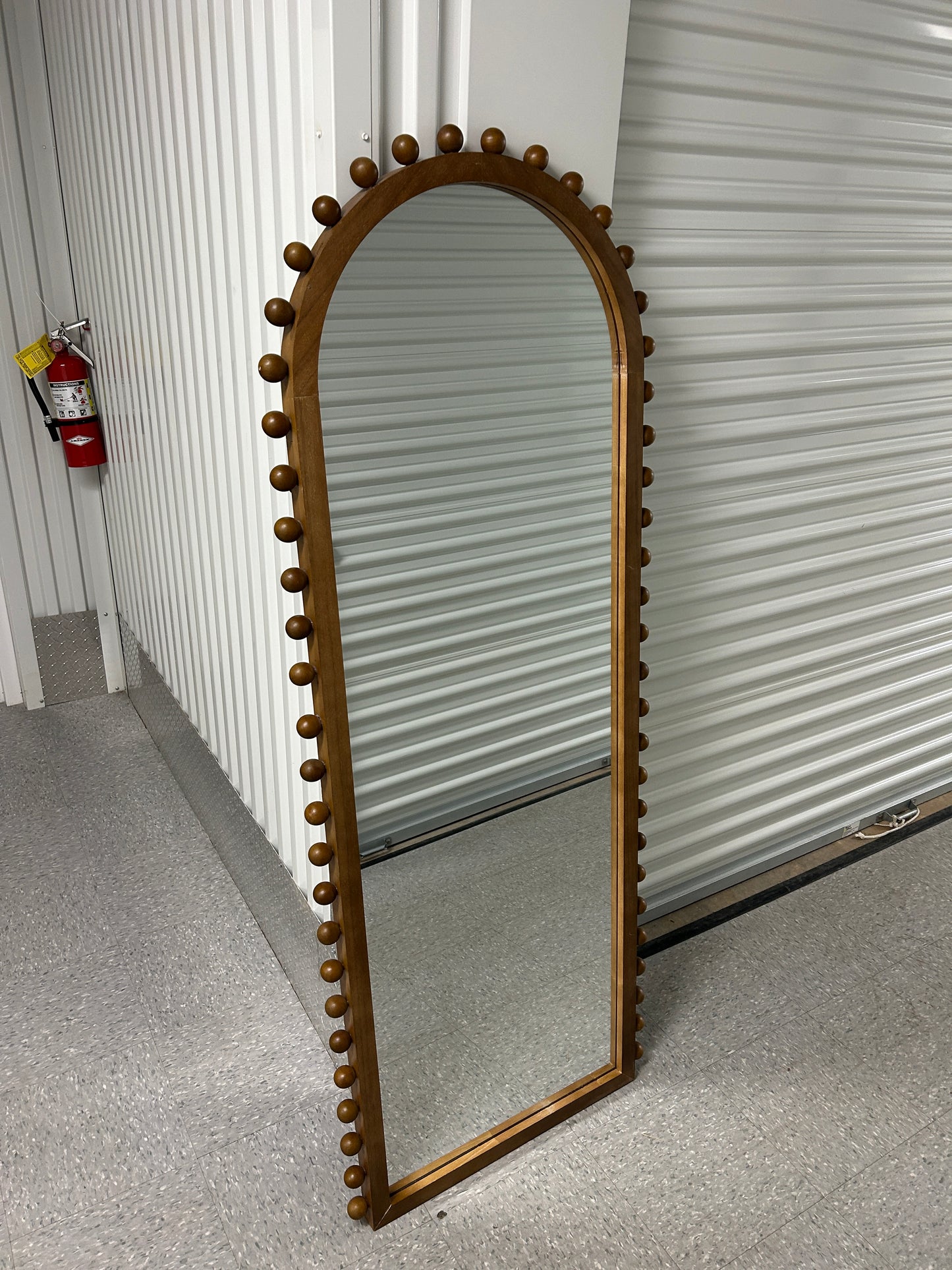Target arched full-length floor mirror with wooden beaded edges.