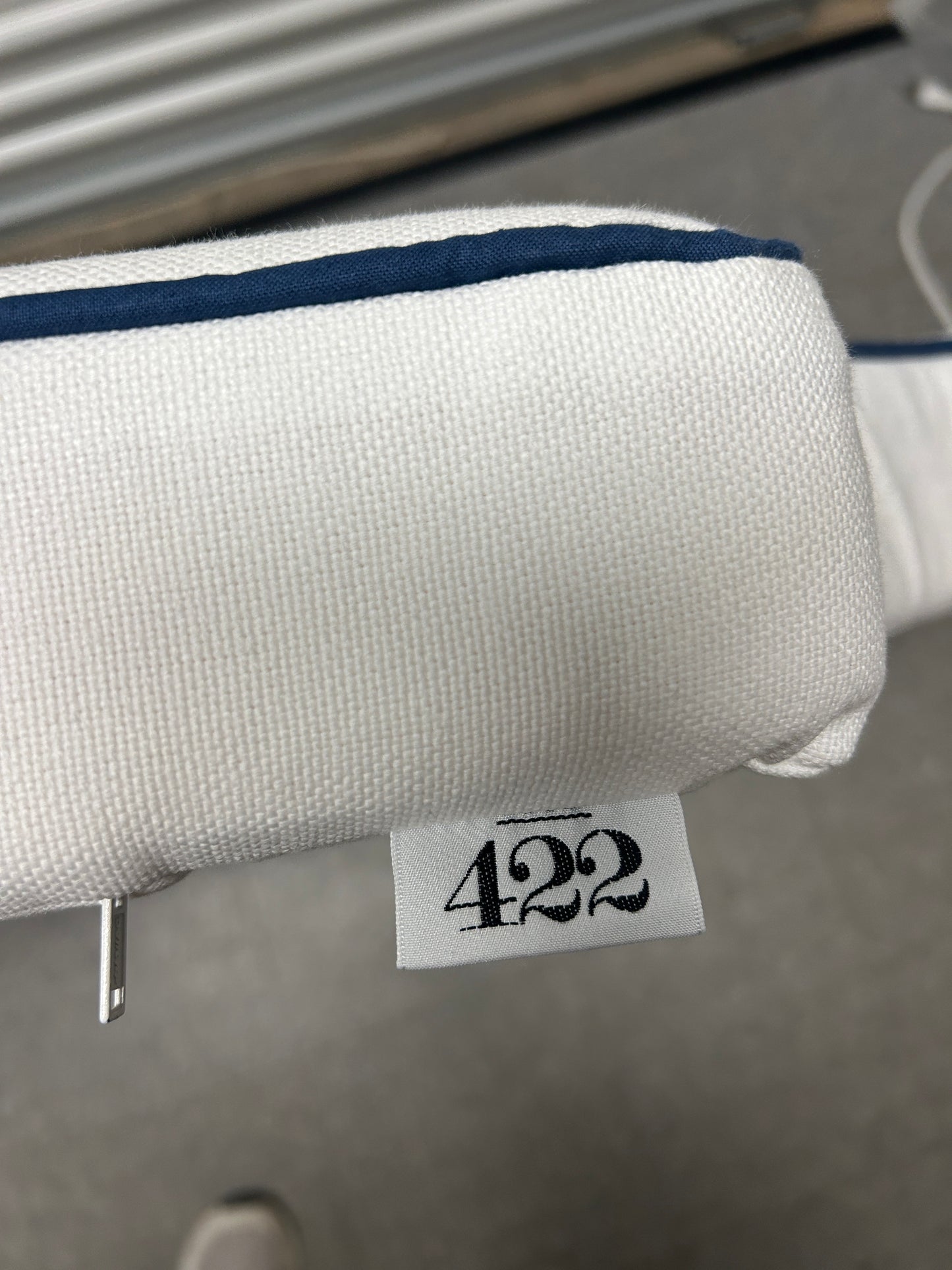 Room 422 twin white headboard with navy blue piping trim along the edges.