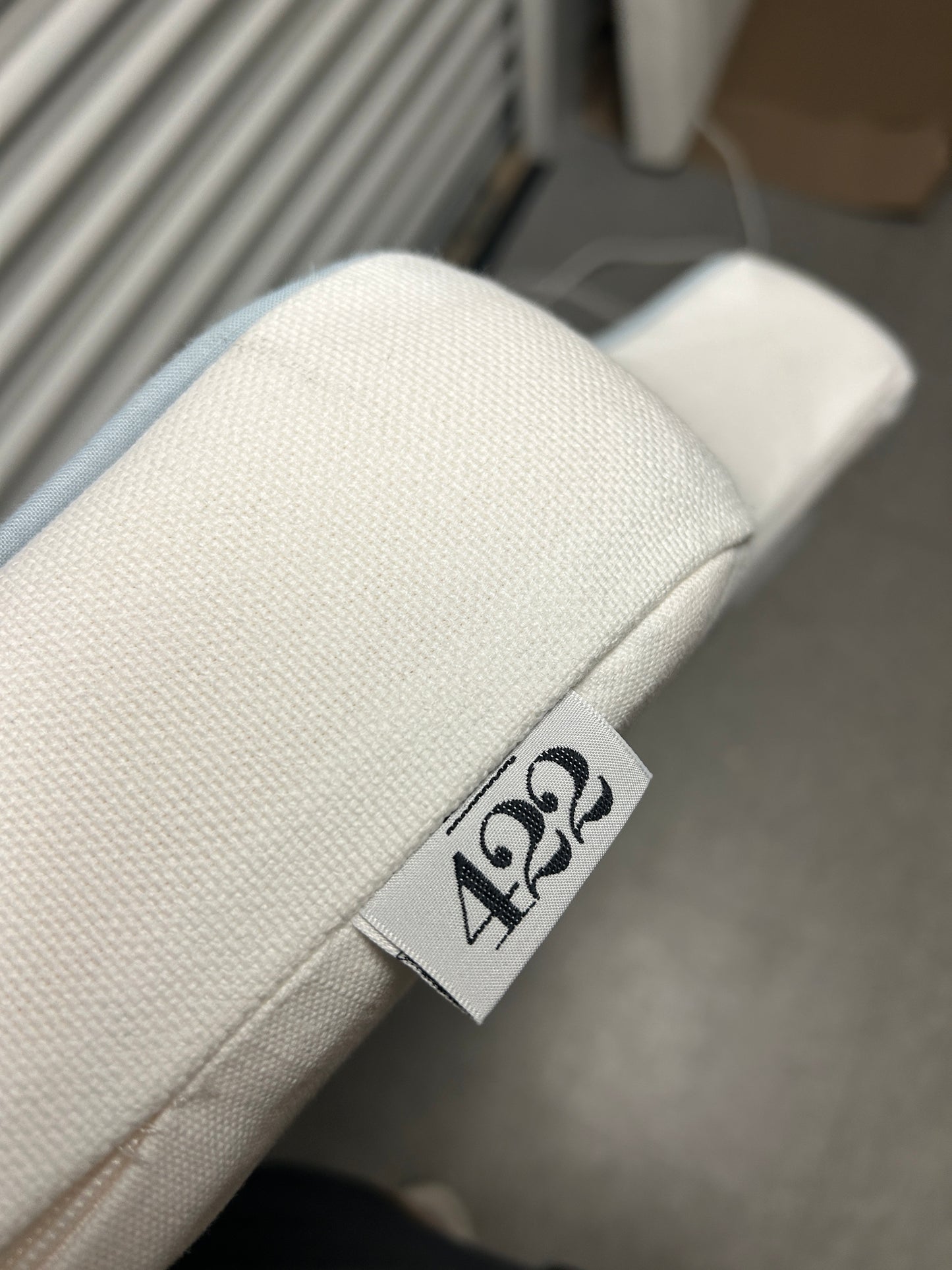 Room 422 twin white headboard with light blue piping trim along the edges.