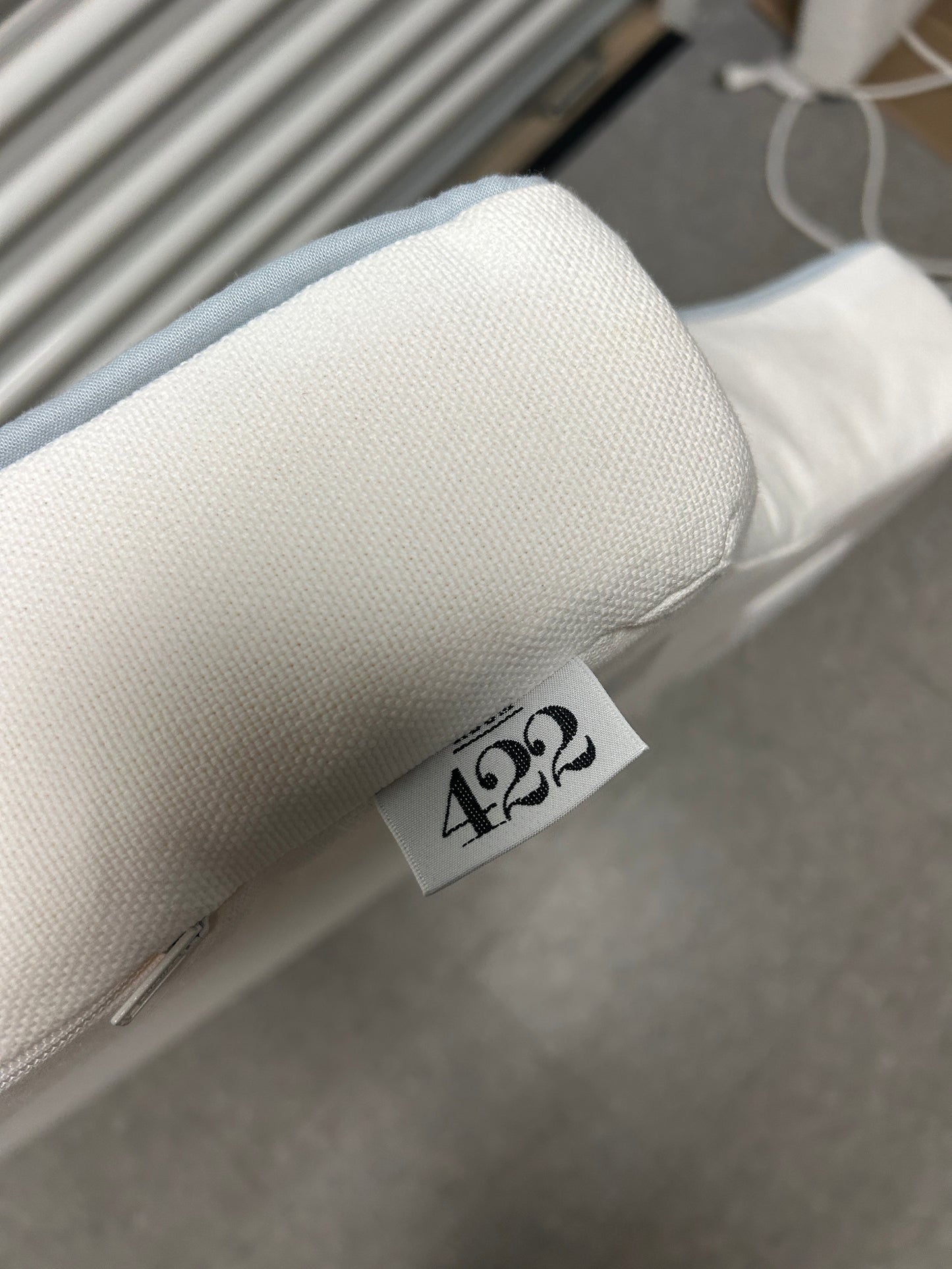 Room 422 twin white headboard with light blue piping trim along the edges.