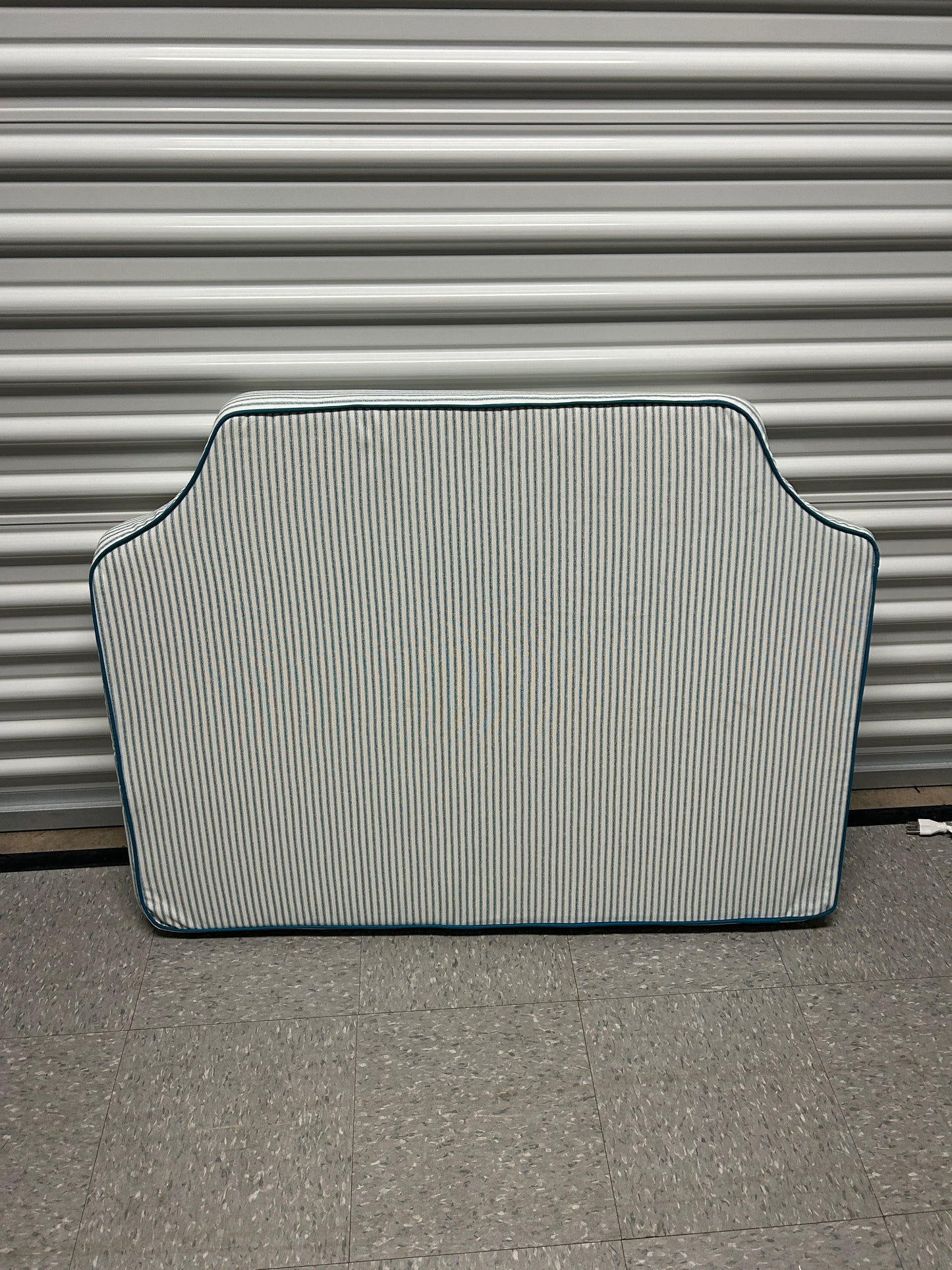 Room 422 twin blue and white striped headboard with blue piping trim along the edges.