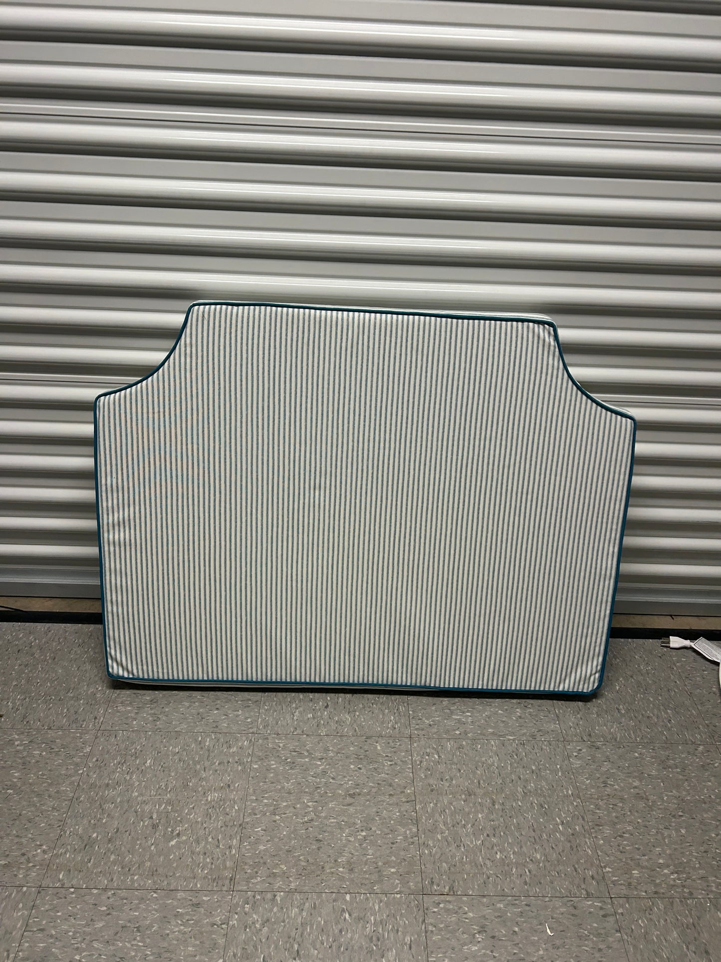 Room 422 twin blue and white striped headboard with blue piping trim along the edges.