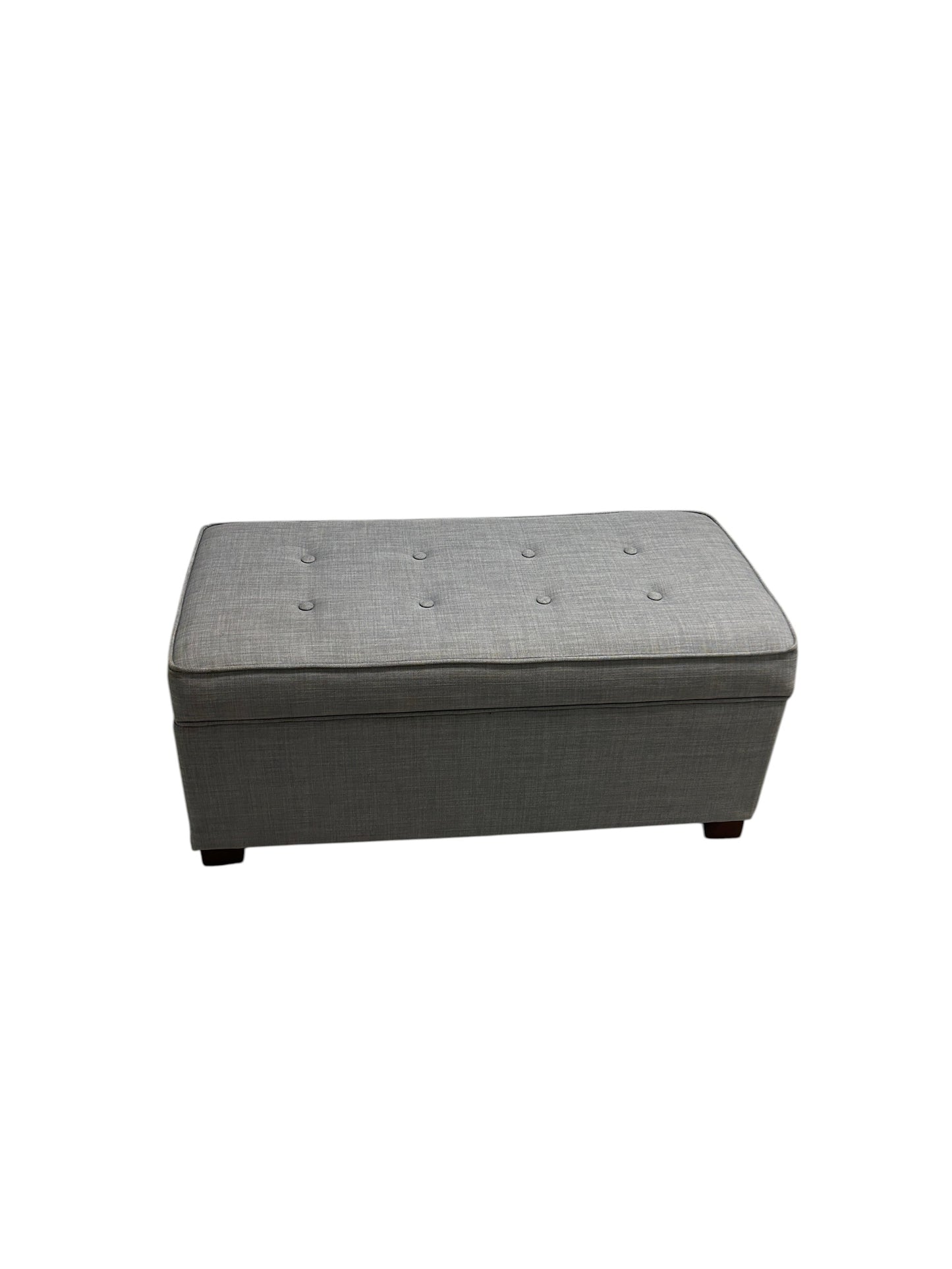 Gray upholstered ottoman bench with tufted top and wooden legs.