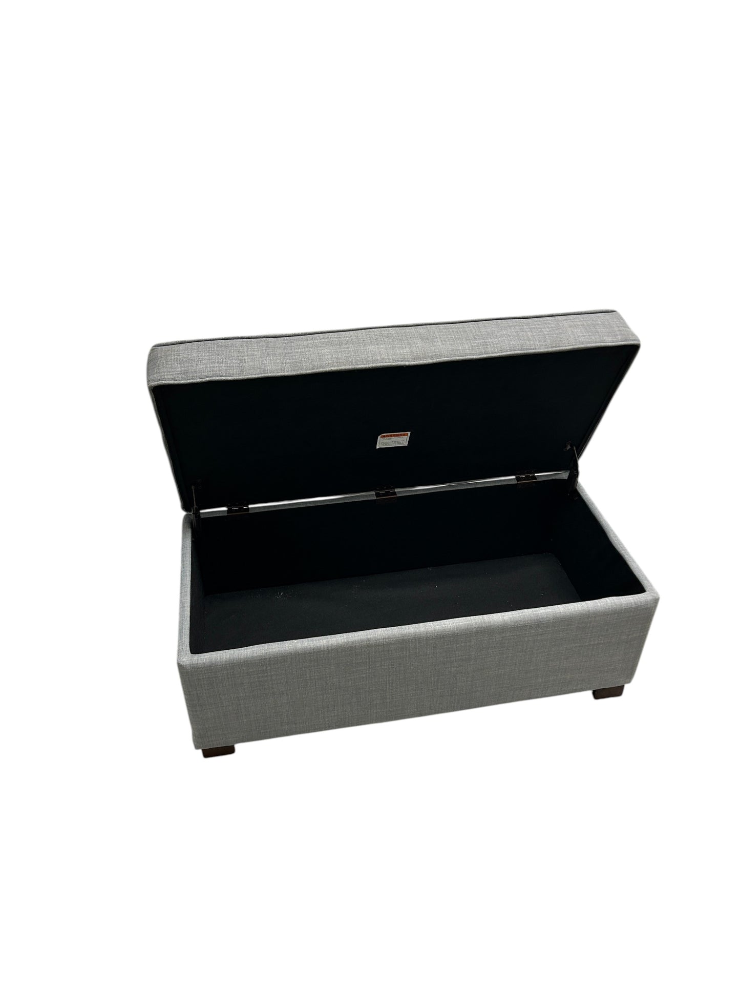 Gray upholstered ottoman bench with tufted top and wooden legs.