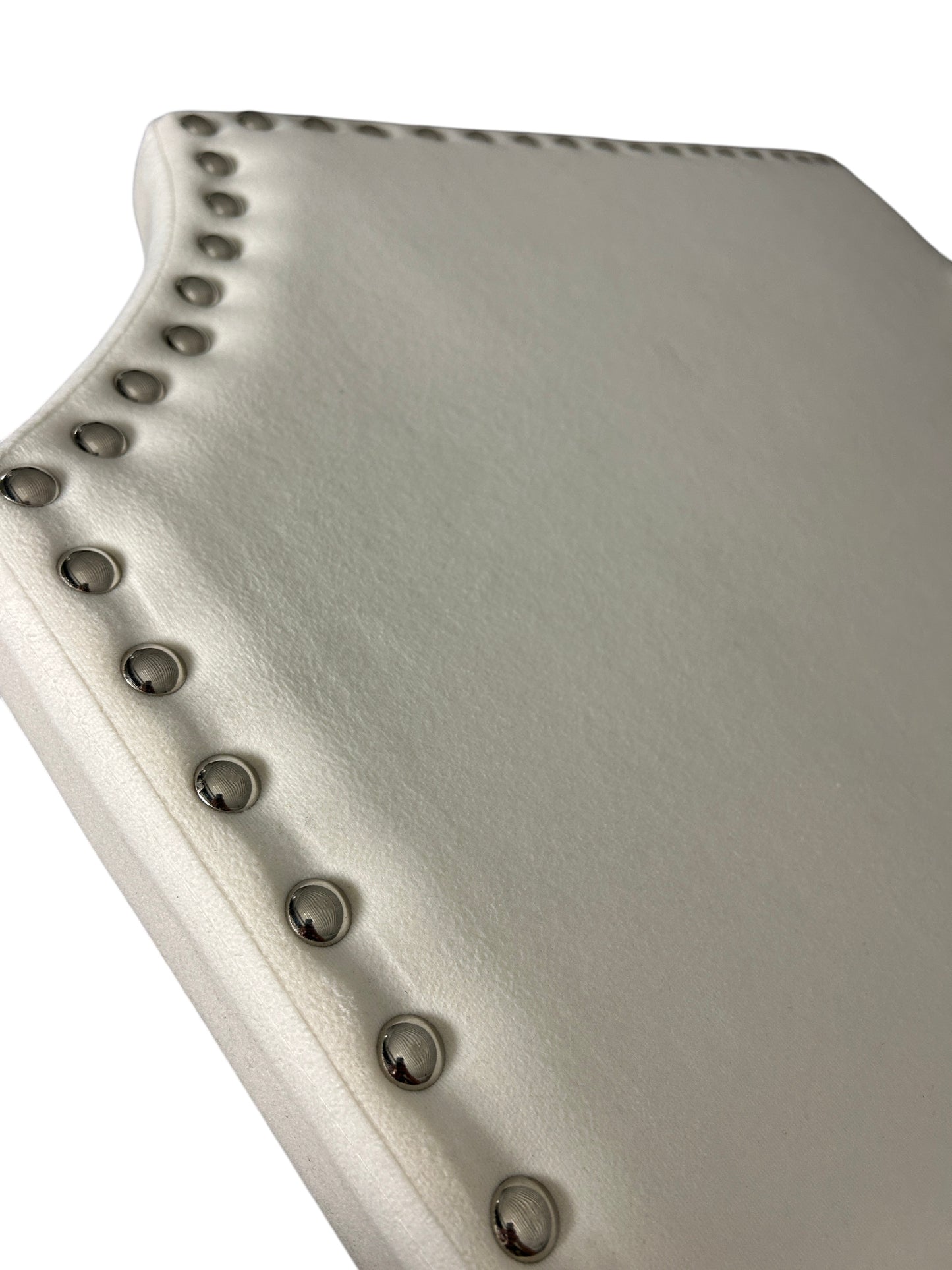 White velvet headboard with silver buttons and wooden legs.