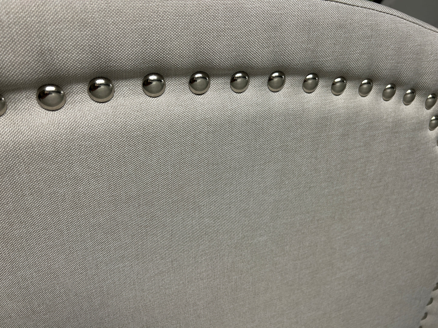 Gray twin headboard with silver buttons and black legs.