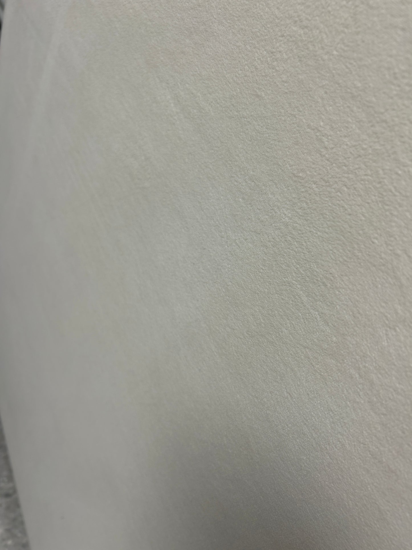 Cream velvet twin headboard with curved notched corners.