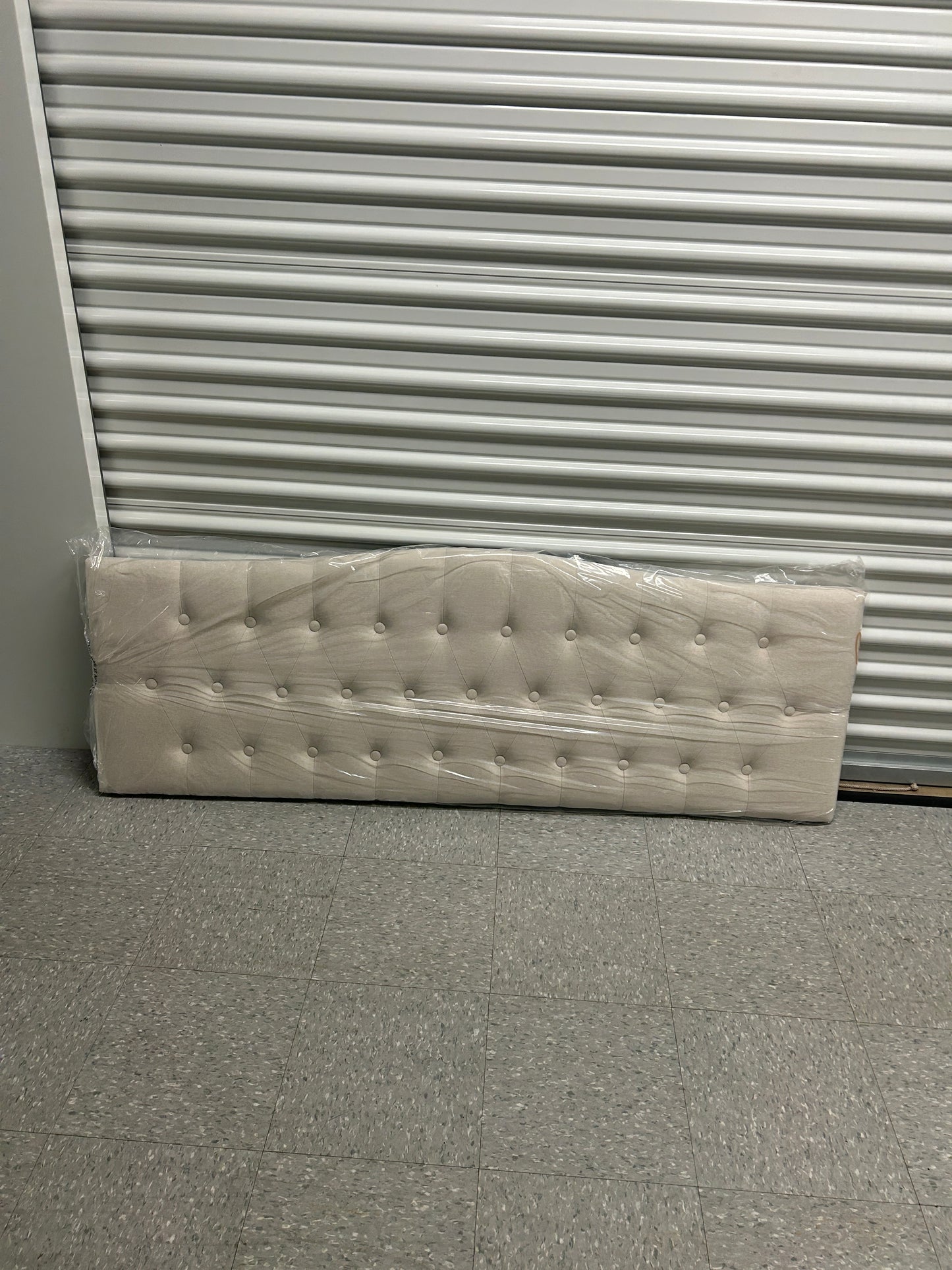 Brand new, still in the box beige queen headboard with wooden legs.