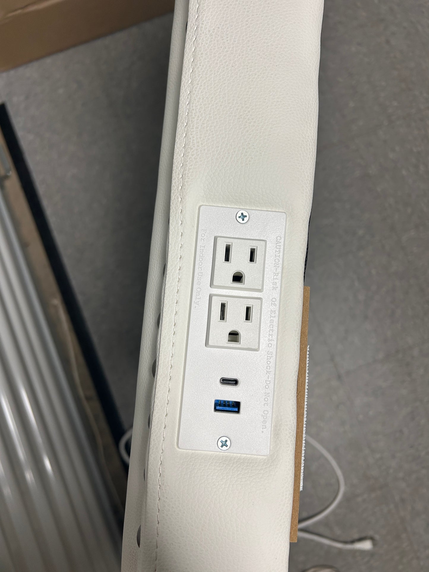White twin headboard with silver buttons and a charging outlet.