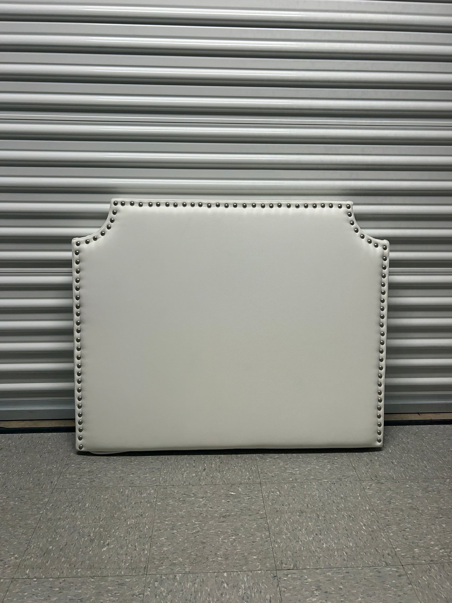 White twin headboard with silver buttons and a charging outlet.