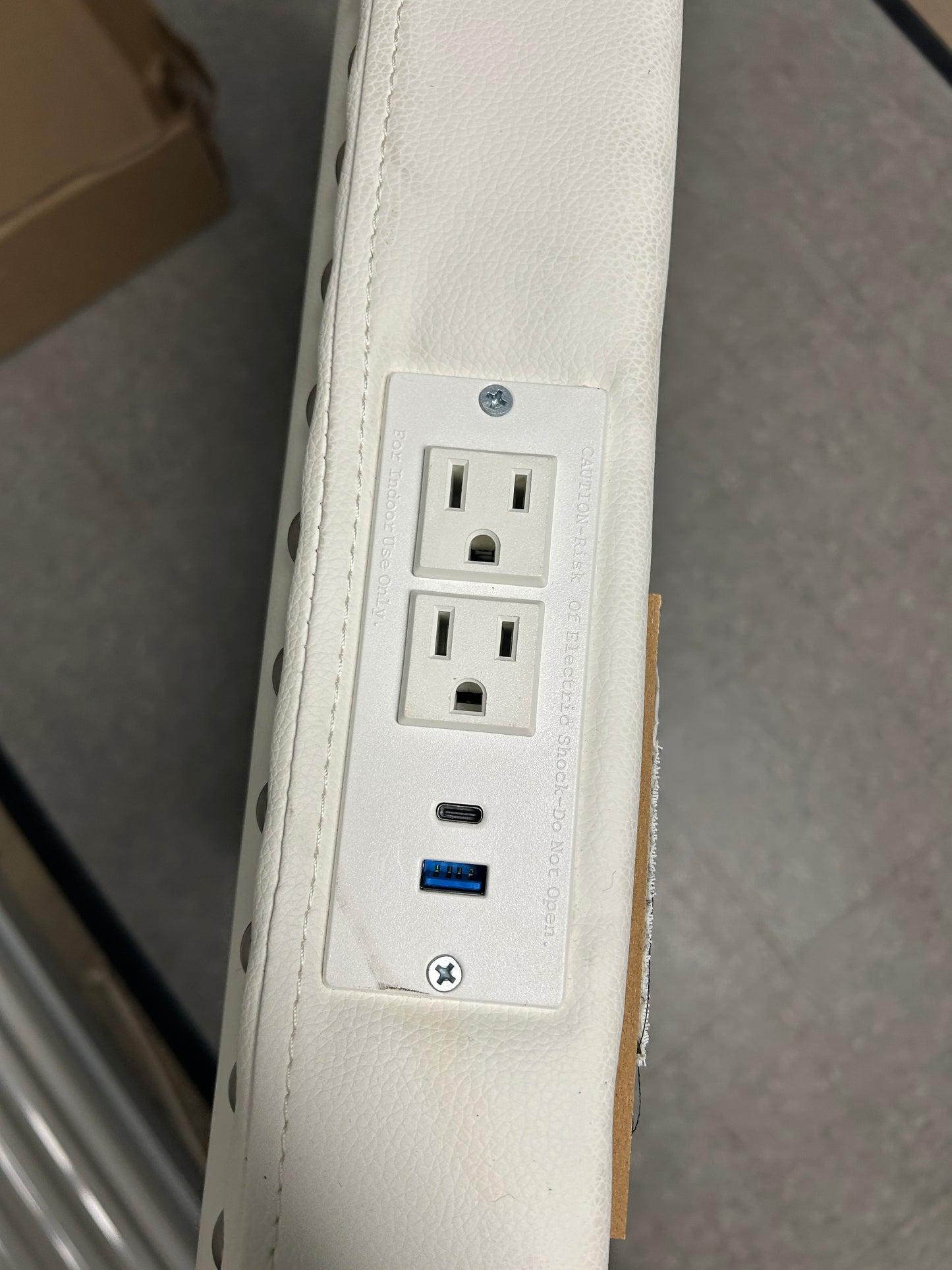 White twin headboard with silver buttons and a charging outlet.