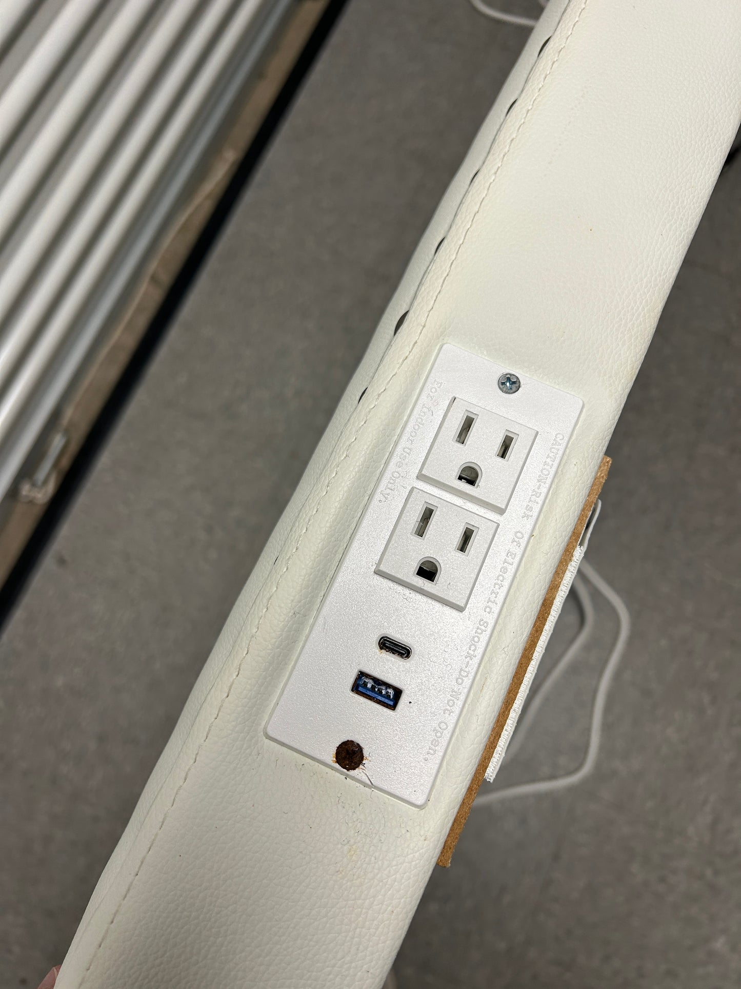 White twin headboard with silver buttons and a charging outlet.