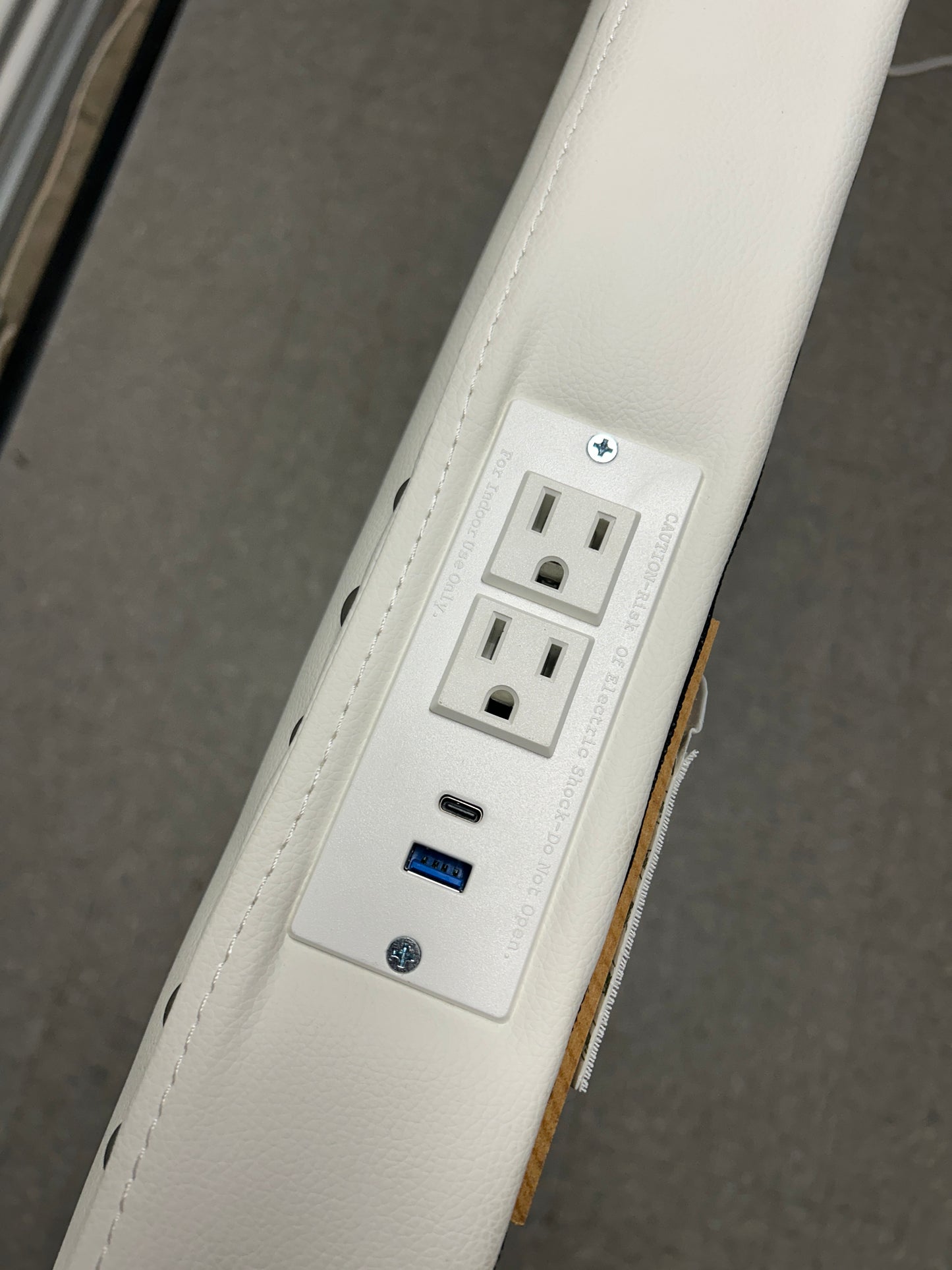 White twin headboard with silver buttons and a charging outlet.