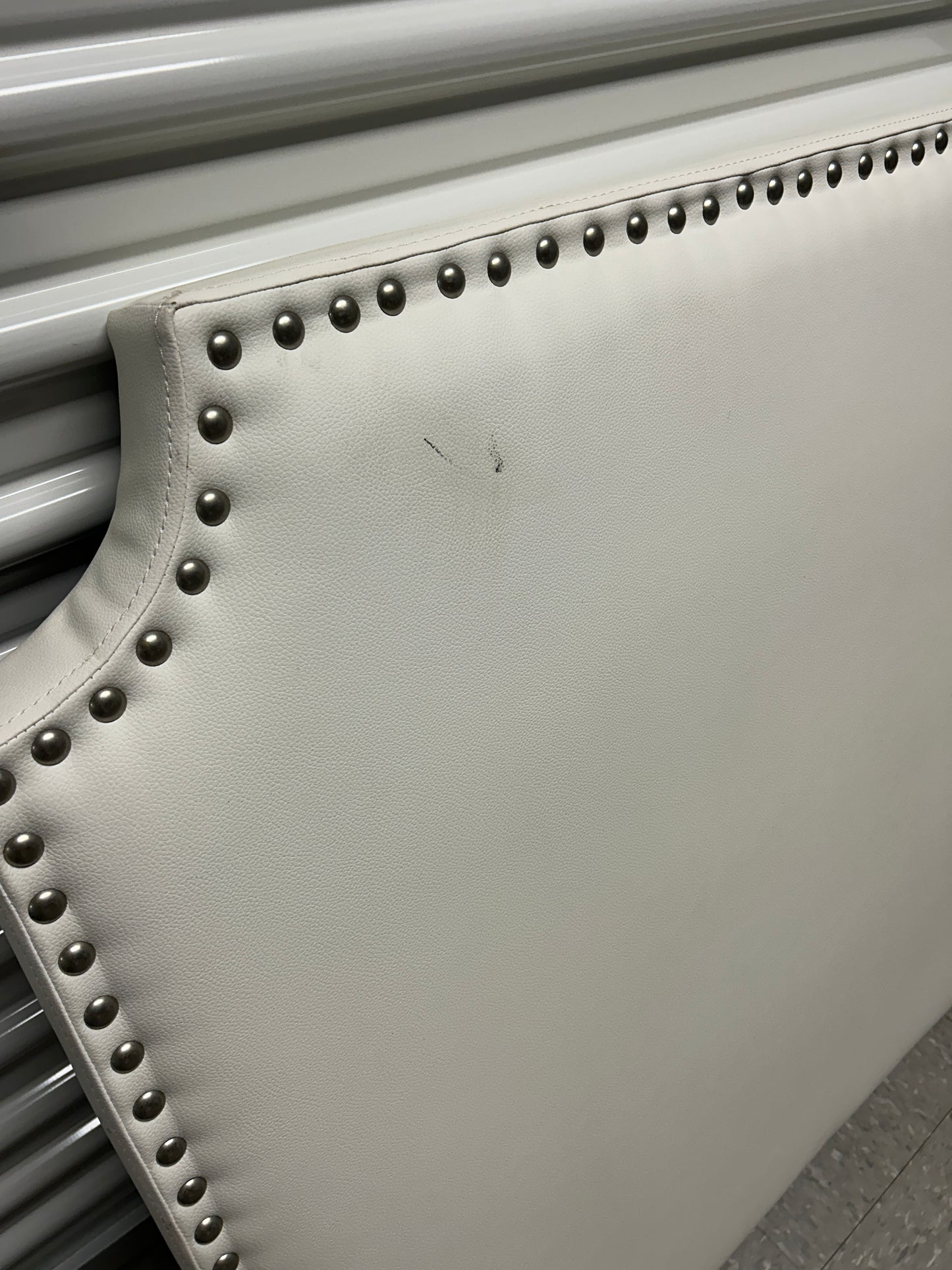 White twin headboard with silver buttons and a charging outlet.