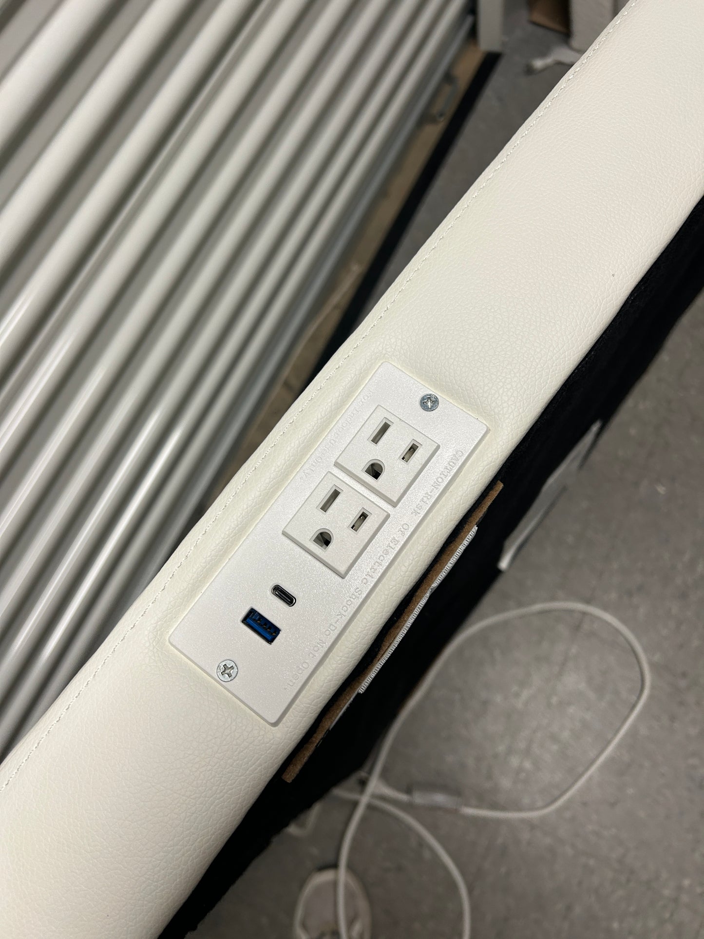 White twin headboard with silver buttons and a charging outlet.