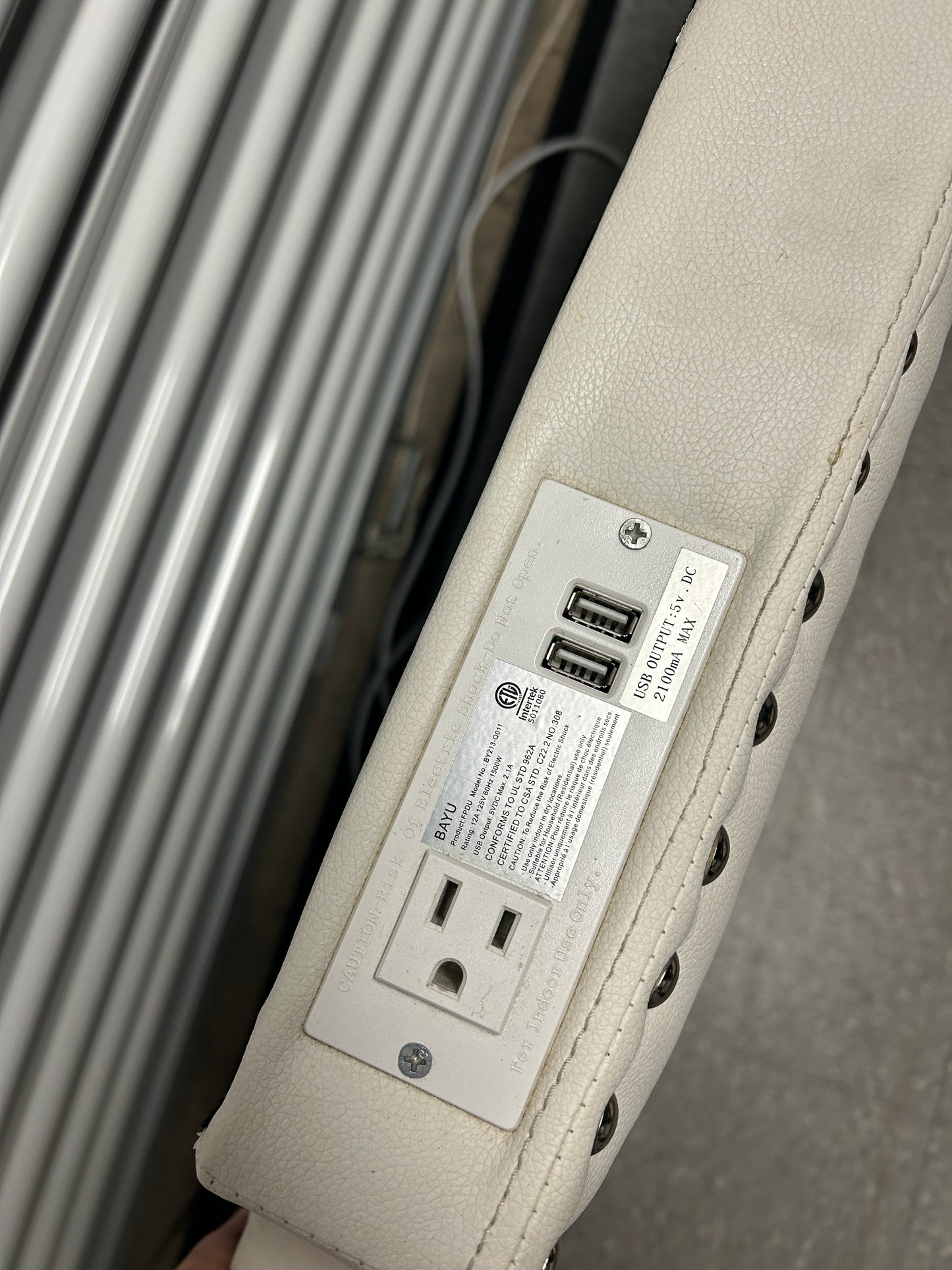 White twin headboard with silver buttons and a charging outlet.