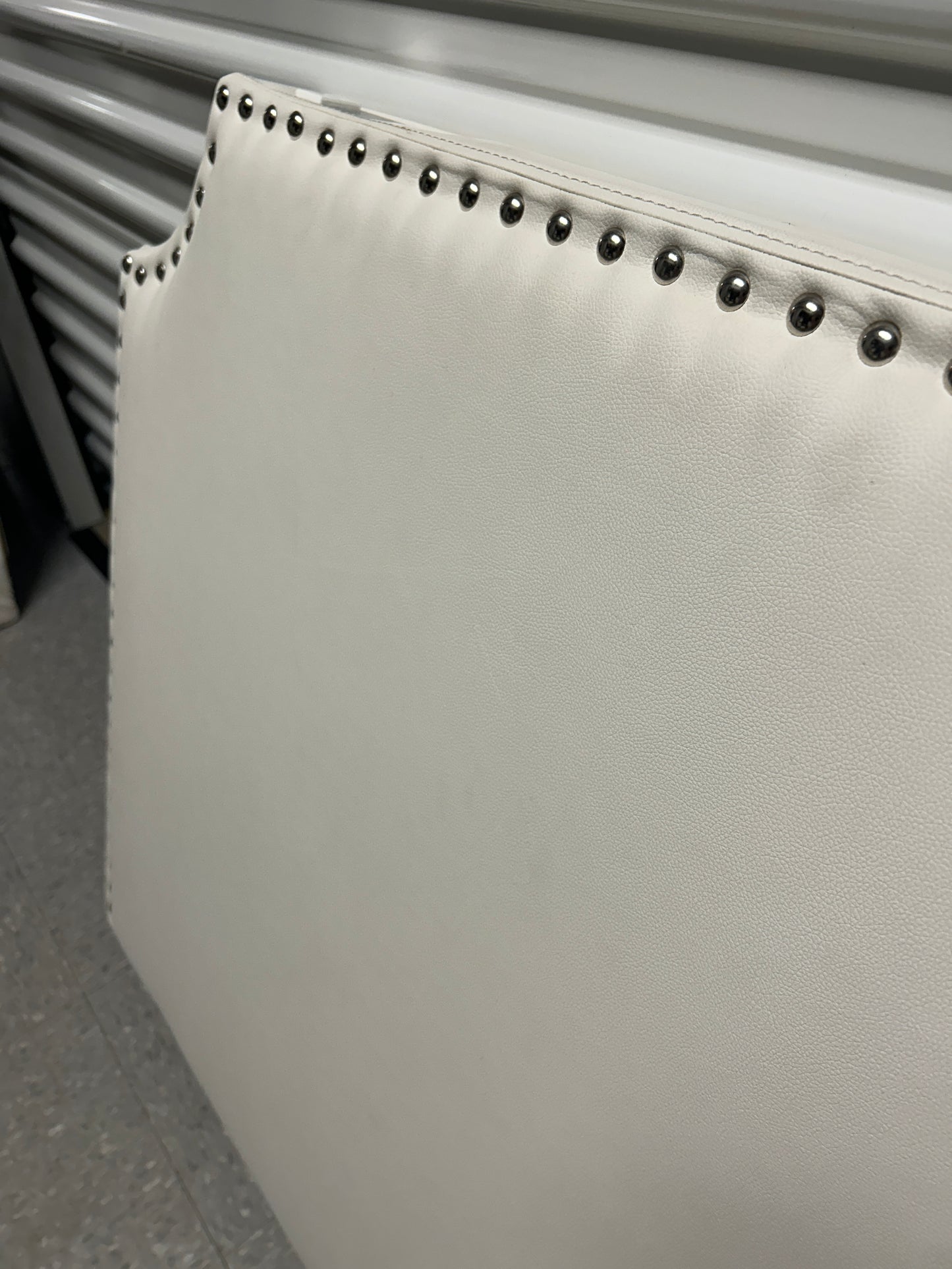 White twin headboard with silver buttons and a charging outlet.
