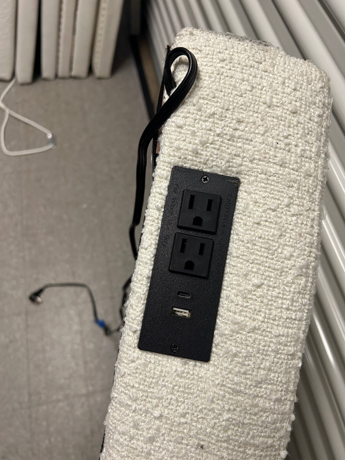 White twin headboard with bouclé fabric and a charging outlet.